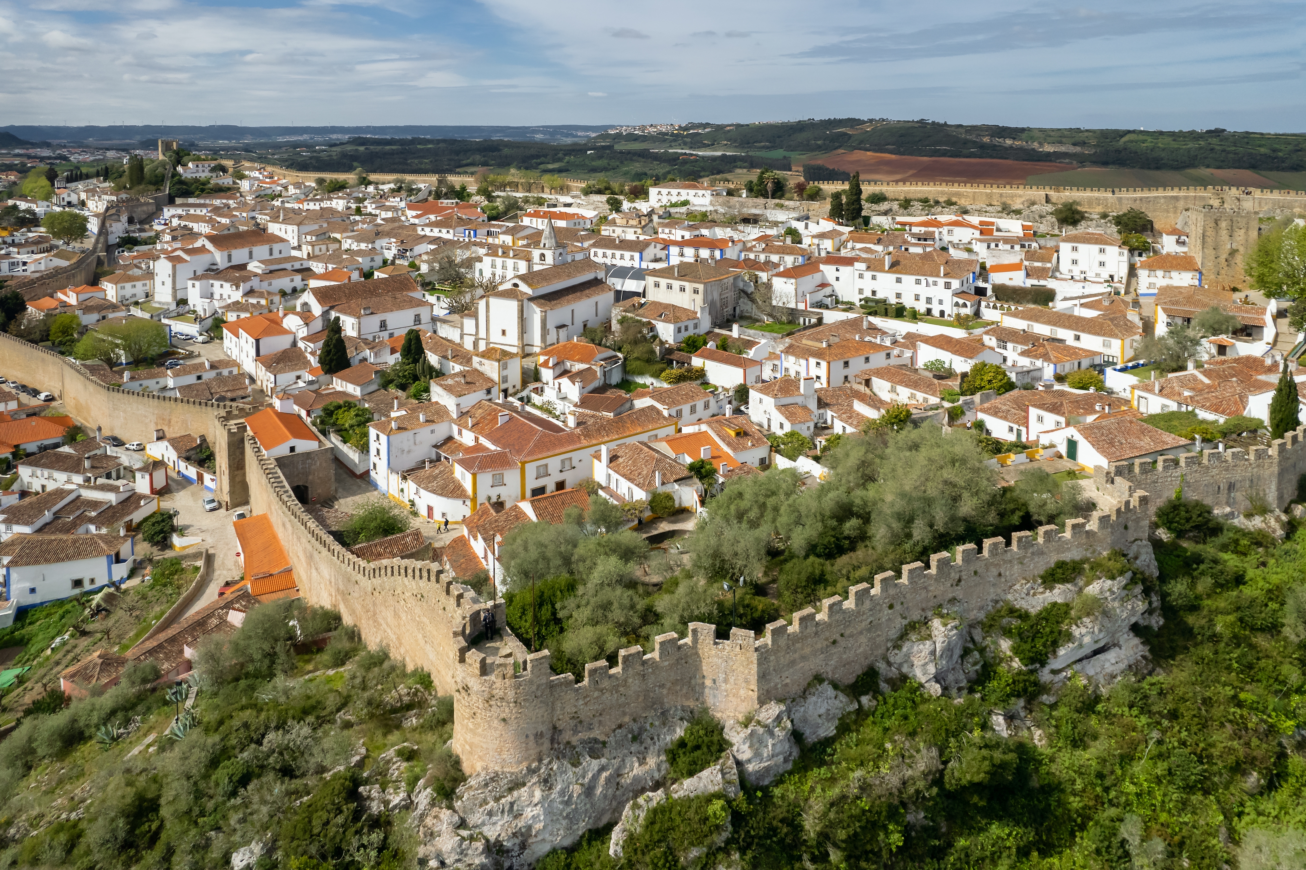 Luftfoto af den charmerende middelalderby Óbidos i Portugal omgivet af historiske bymure og med hvide huse med orange tagsten