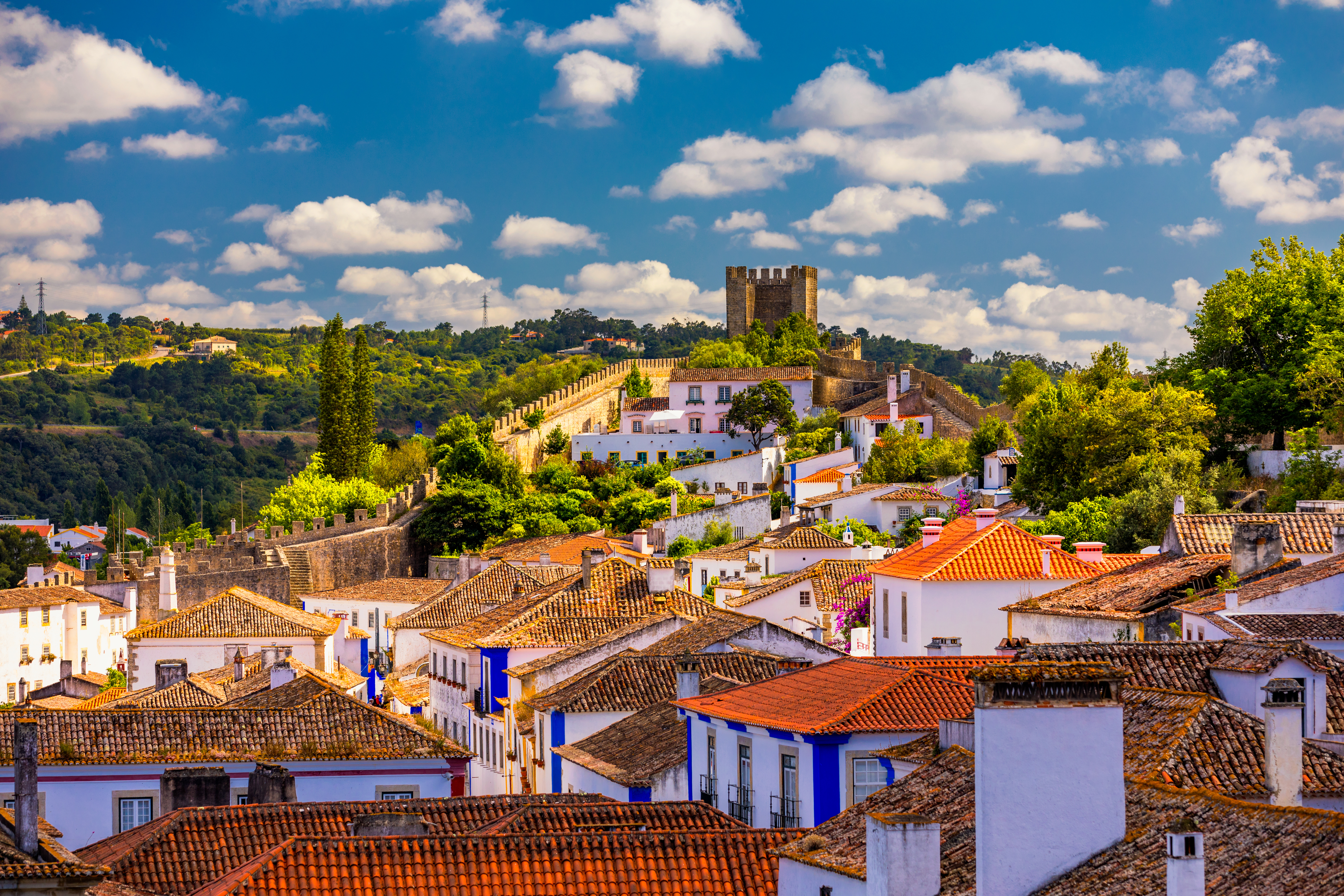 Panoramaudsigt over den historiske by Óbidos i Portugal med middelalderlig fæstning, bymure og charmerende hvide huse med røde tage