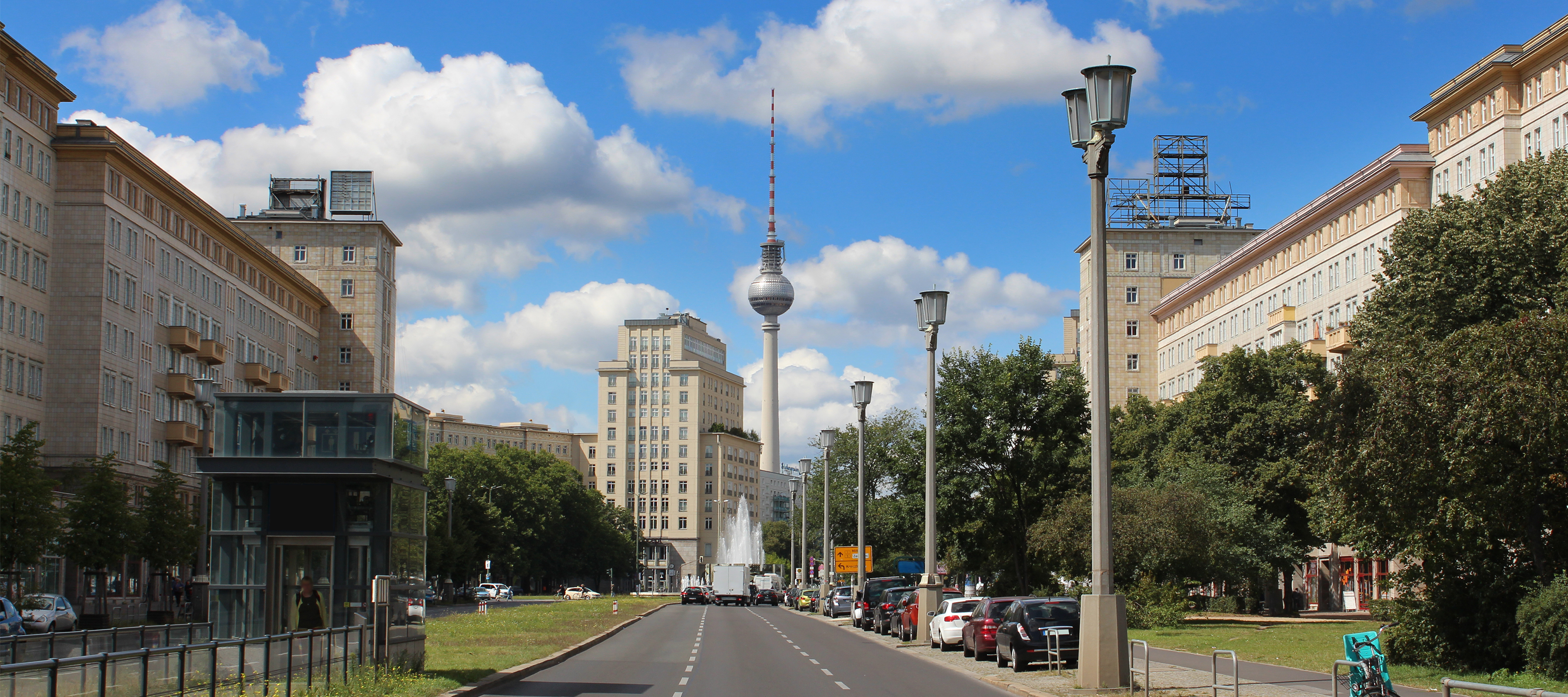 Smukt udsyn ned ad Karl-Marx-Allee i Berlin med det kendte Fernsehturm tårn og historisk DDR-arkitektur