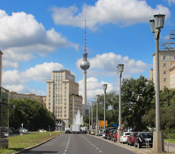 Smukt udsyn ned ad Karl-Marx-Allee i Berlin med det kendte Fernsehturm tårn og historisk DDR-arkitektur