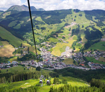 Saalbach-Hinterglemm bjergferie med kabelbane over grøn alpedal i Østrig