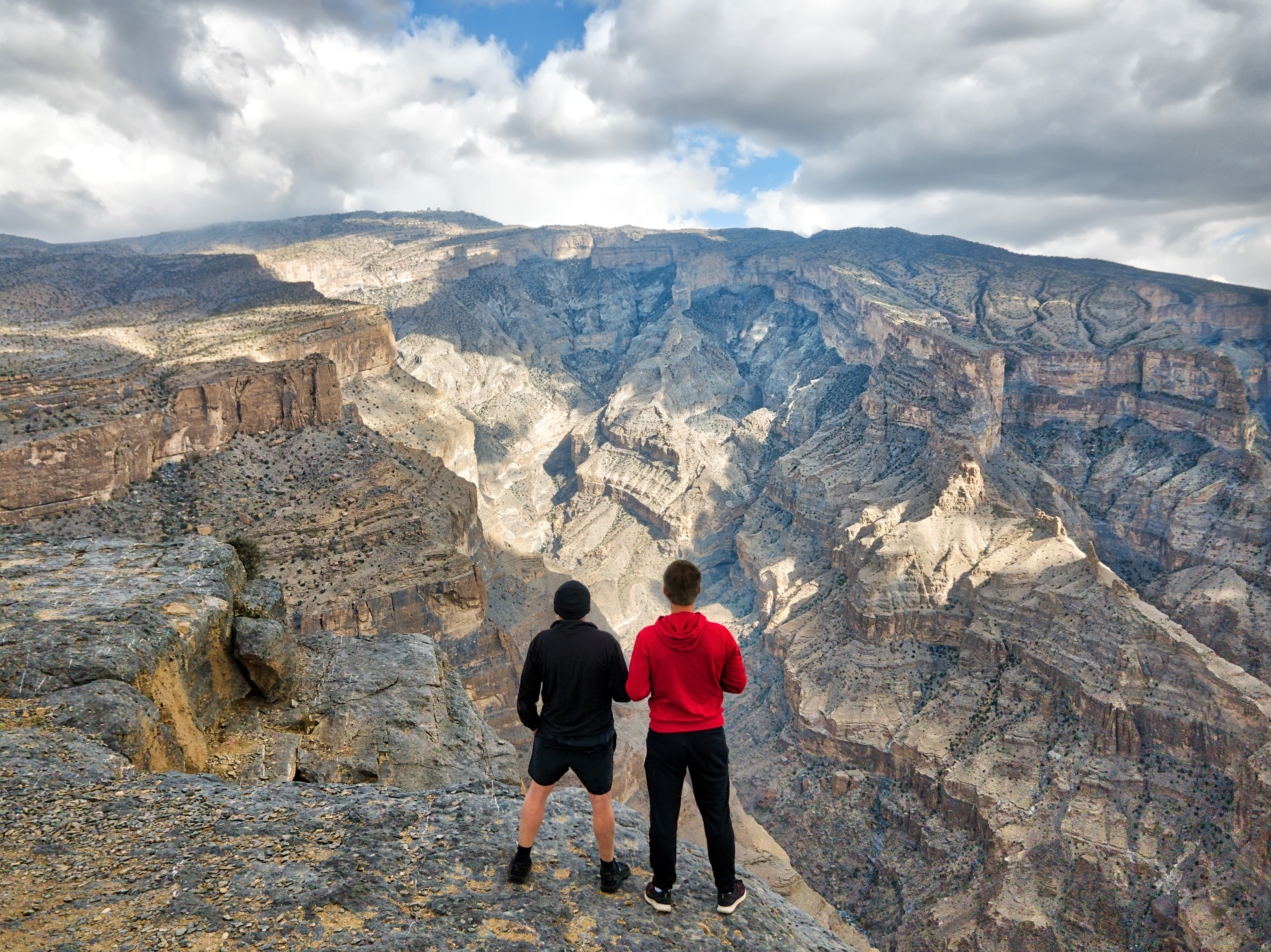 Naturelskere på vandretur i Omans Hajar-bjerge med storslået canyon-udsigt