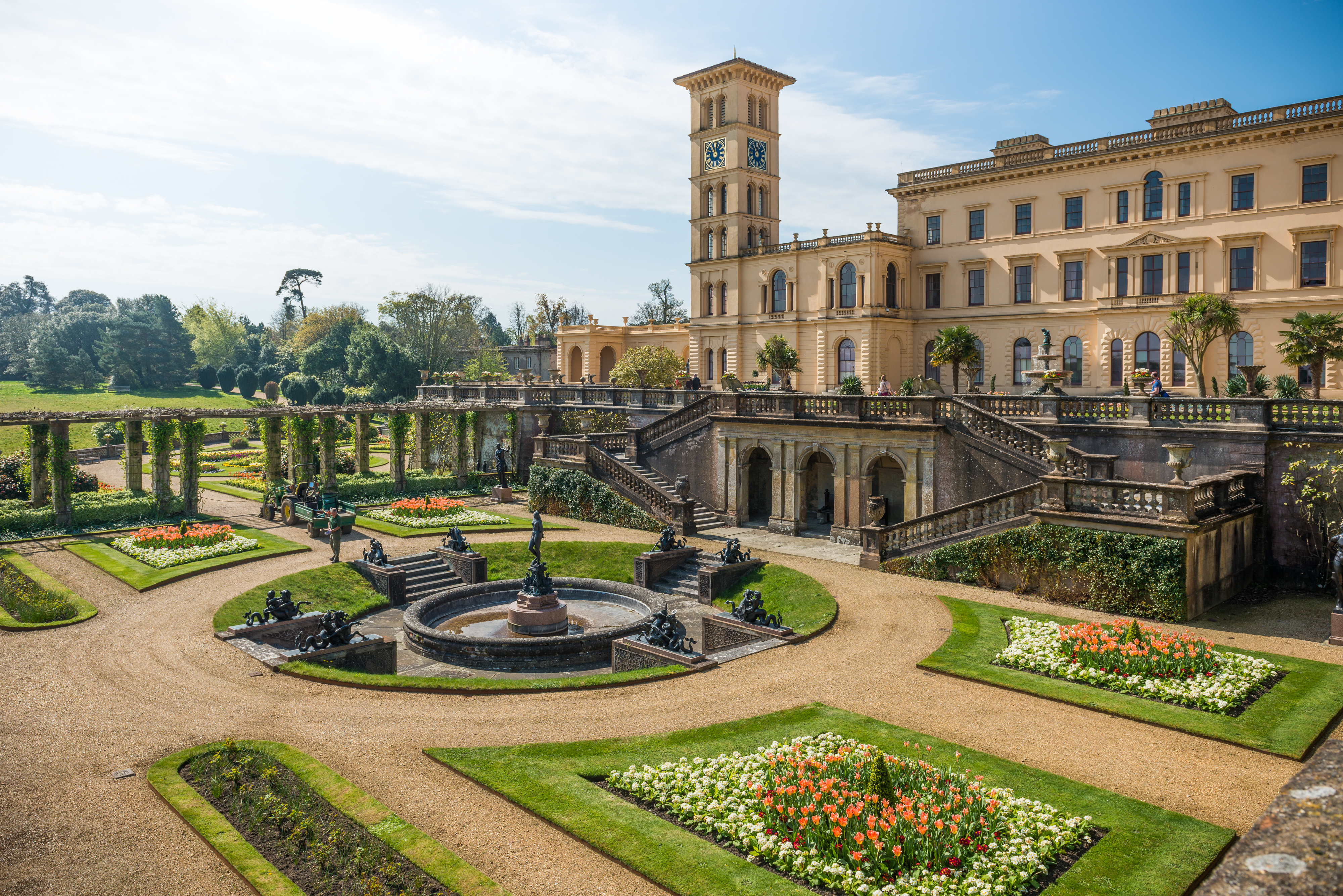 Osborne House på Isle of Wight med storslåede formelle haver, blomsterbed med tulipaner og den karakteristiske klokkentårn under blå sommerhimmel