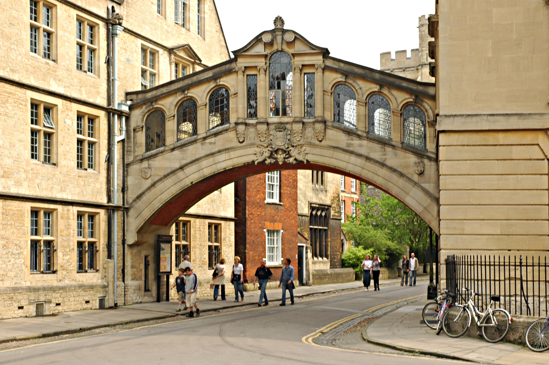 Arkitektonisk mestervark Bridge of Sighs i Oxford med gyldne sten bygninger og fodgaengere paa gaden