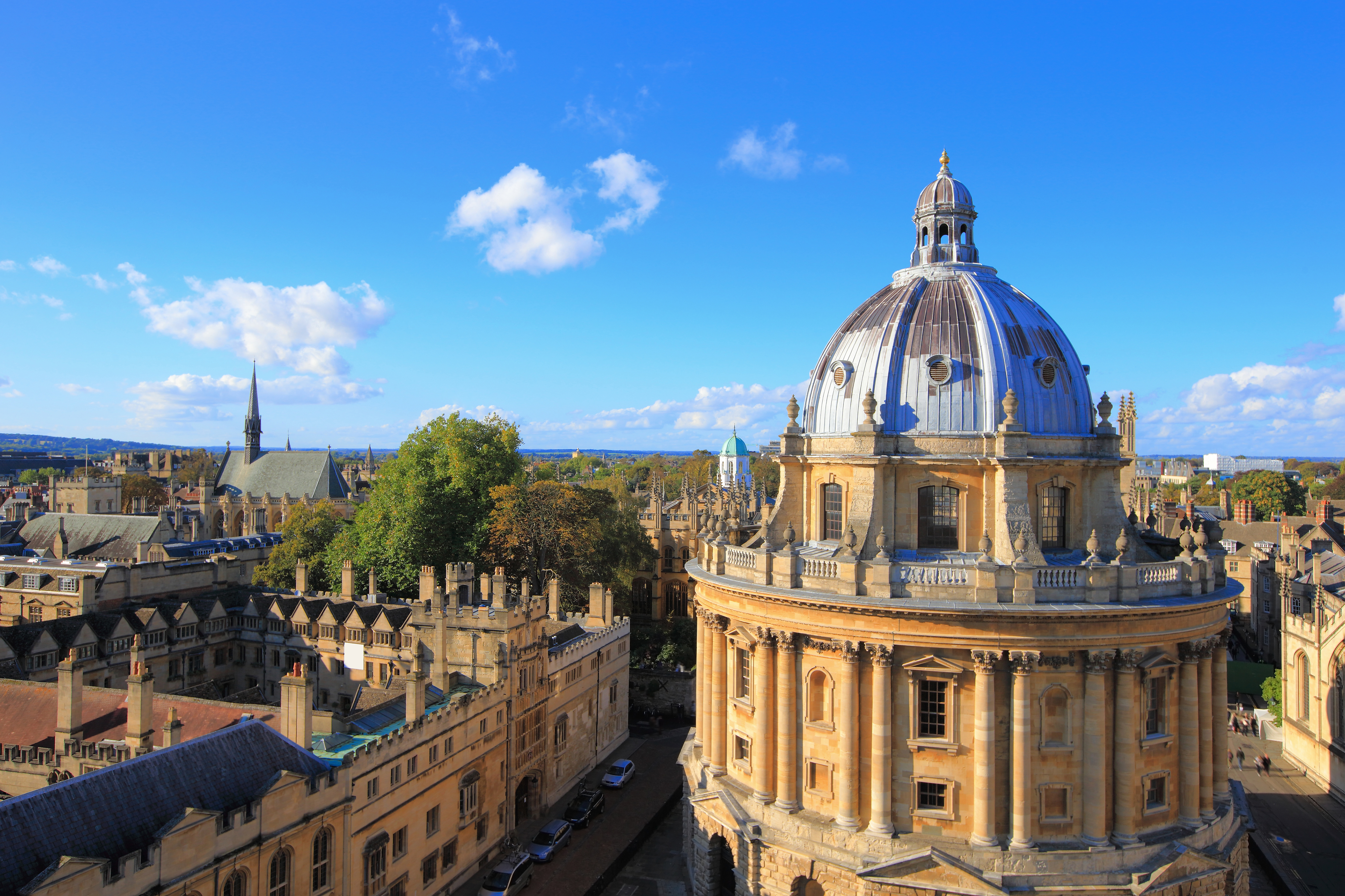 Fantastisk fugleperspektiv over Oxford Universitets historiske bygninger med den prominente Radcliffe Camera kuppel og de omkringliggende kollegier under en blå himmel