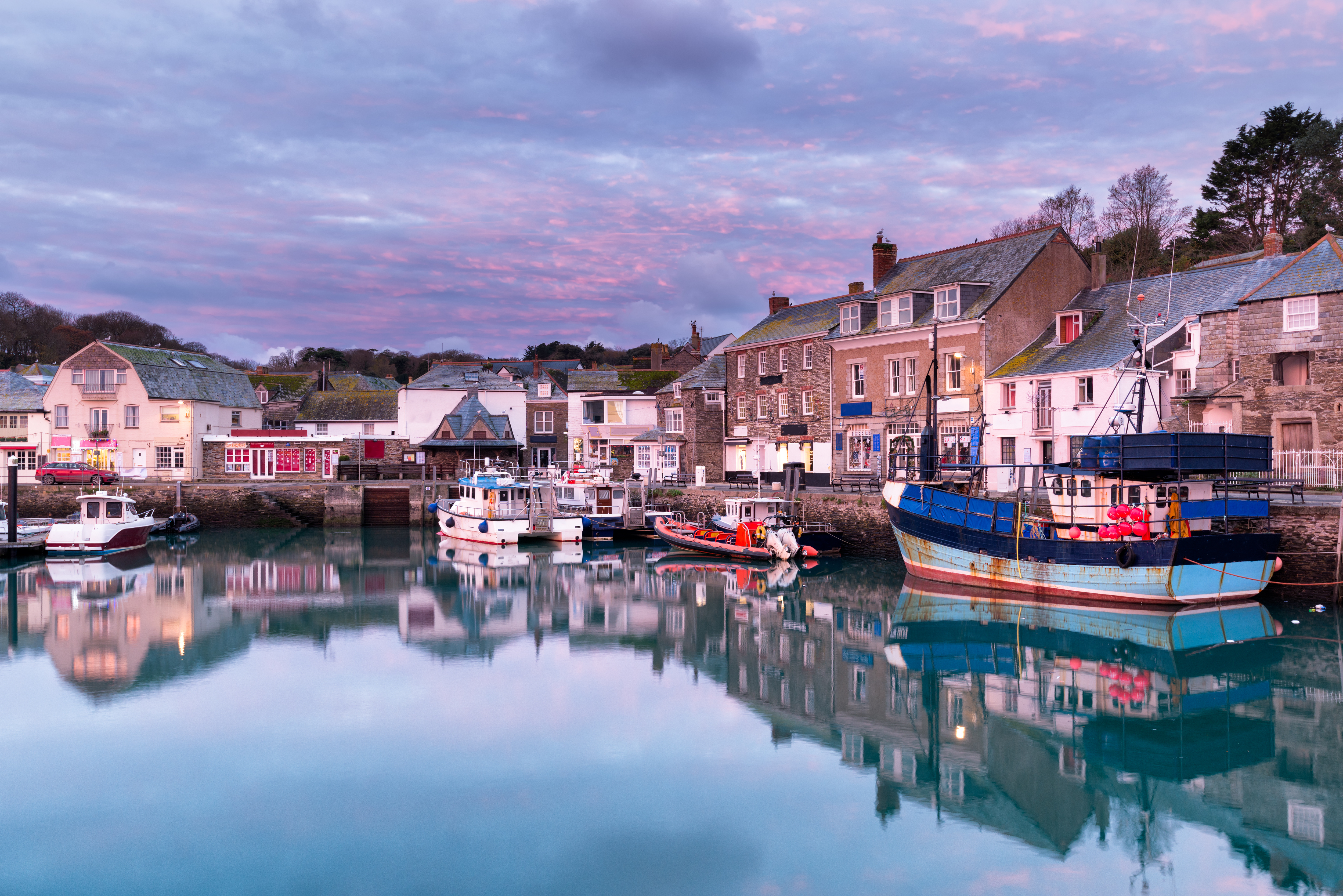 Malerisk havneby Padstow i Cornwall med farvestrålende fiskerbåde og perfekte vandrefleksioner