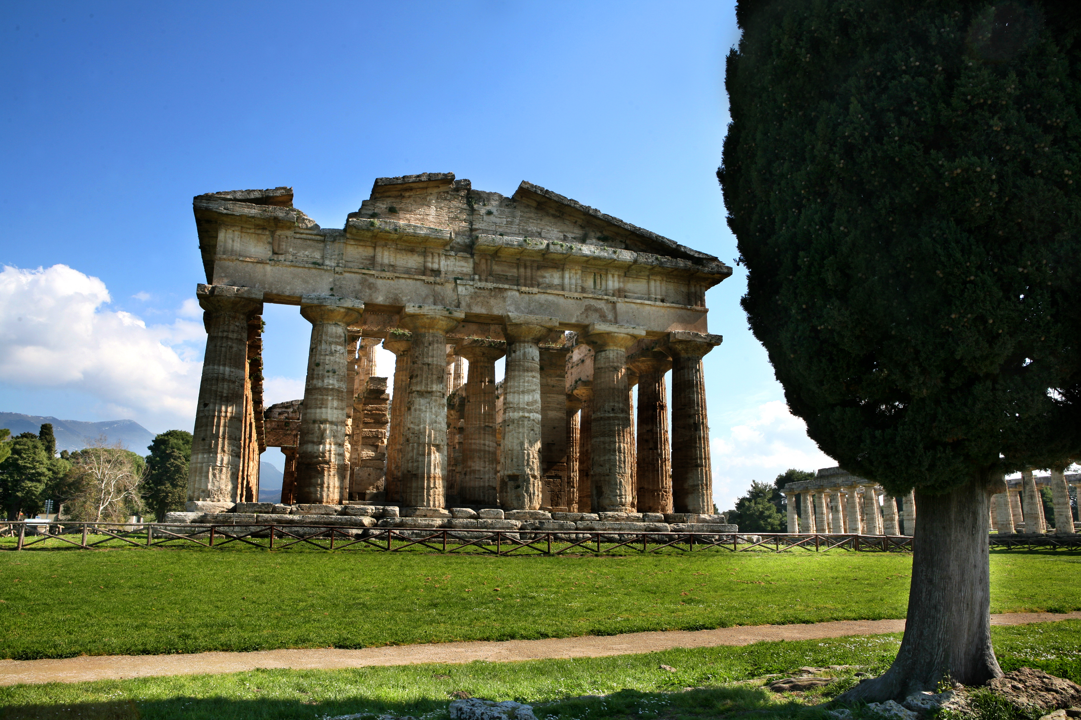De velbevarede antikke tempelsøjler i Paestum, Campania i Italien under en smuk blå himmel