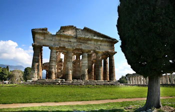 De velbevarede antikke tempelsøjler i Paestum, Campania i Italien under en smuk blå himmel