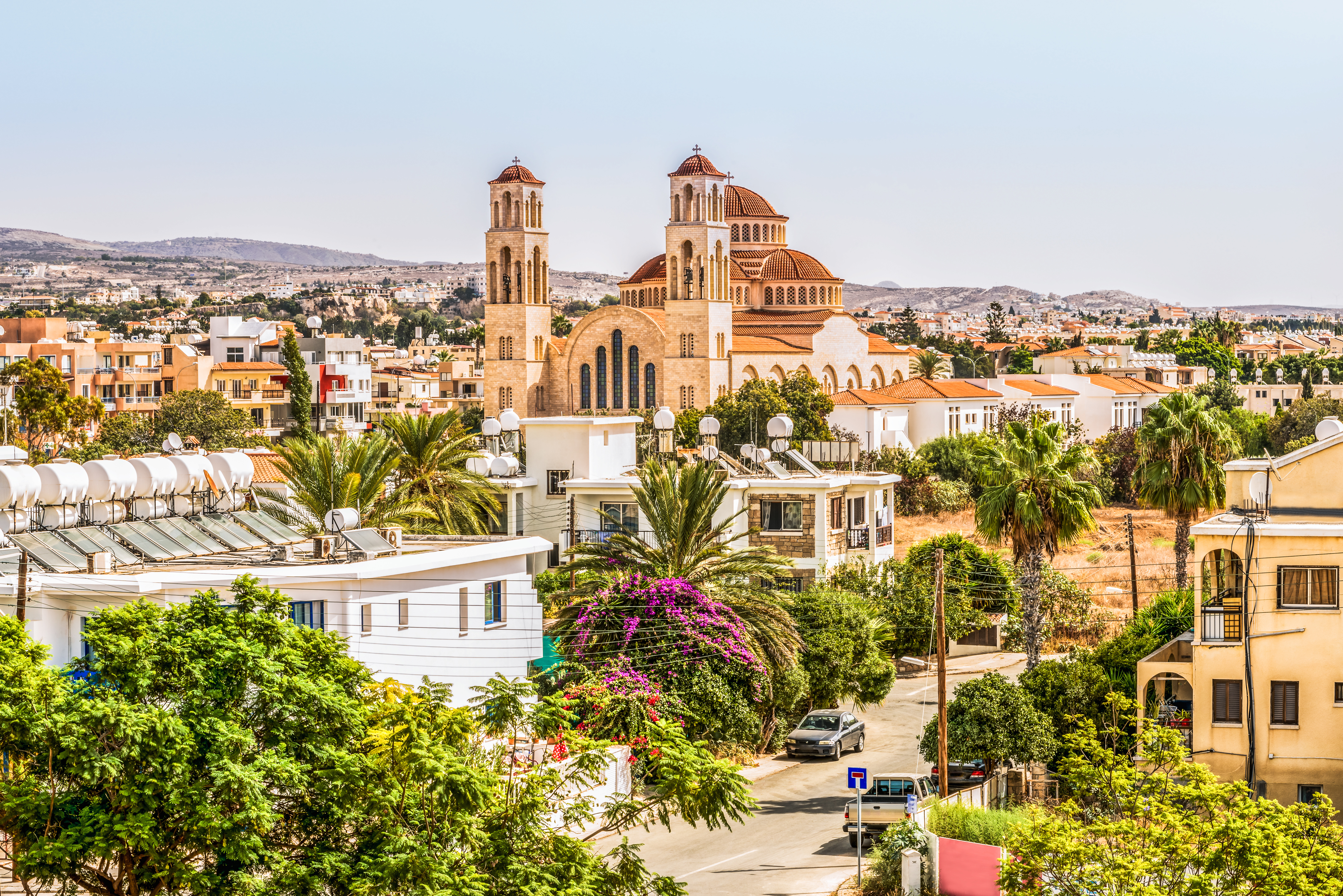 Flot panoramaudsigt over Paphos på Cypern med ortodoks katedral, palmer og farverige blomster i det traditionelle bymiljø