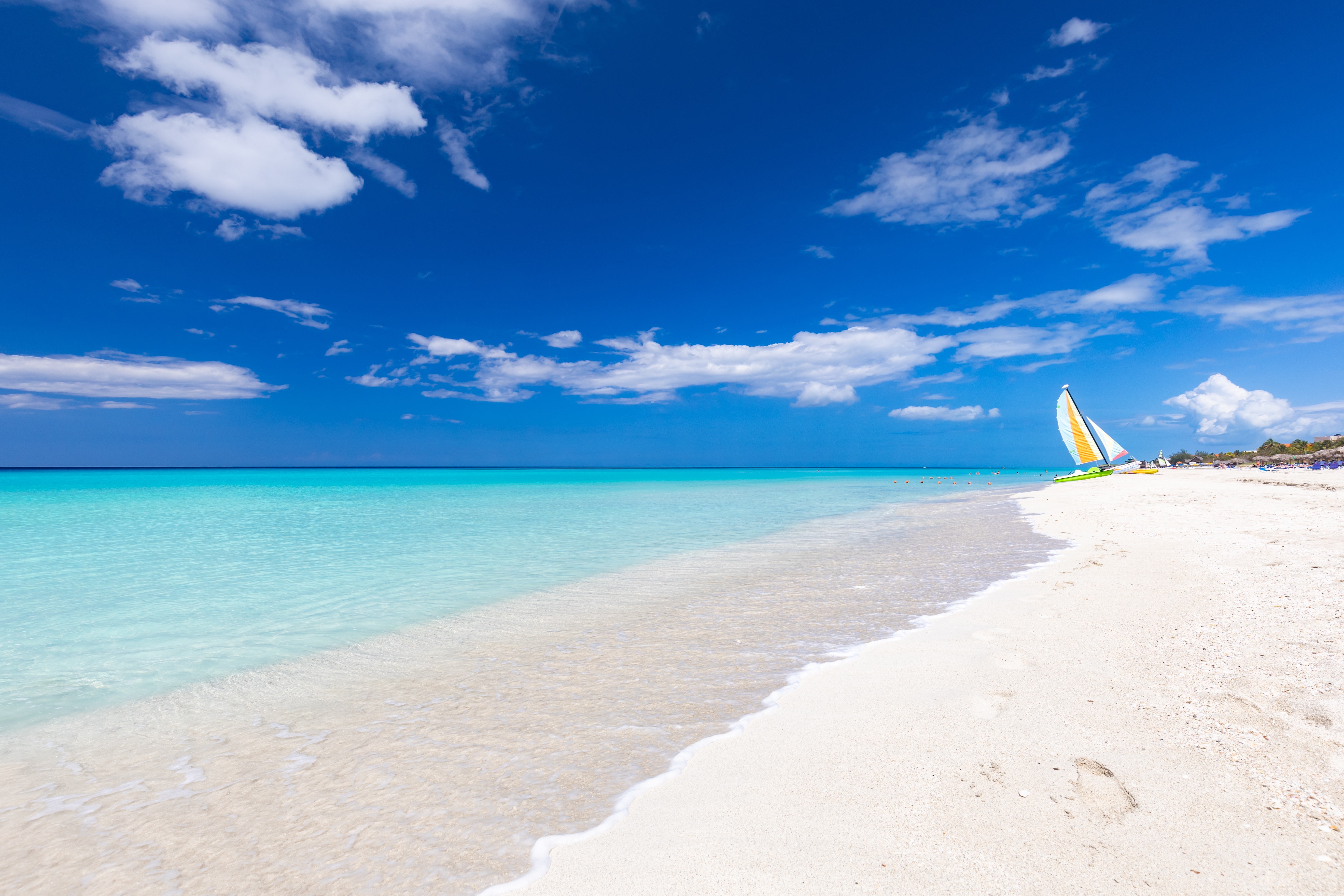 Paradisstrand på Cuba med hvidt sand, krystalklart vand og blå himmel med hvide skyer