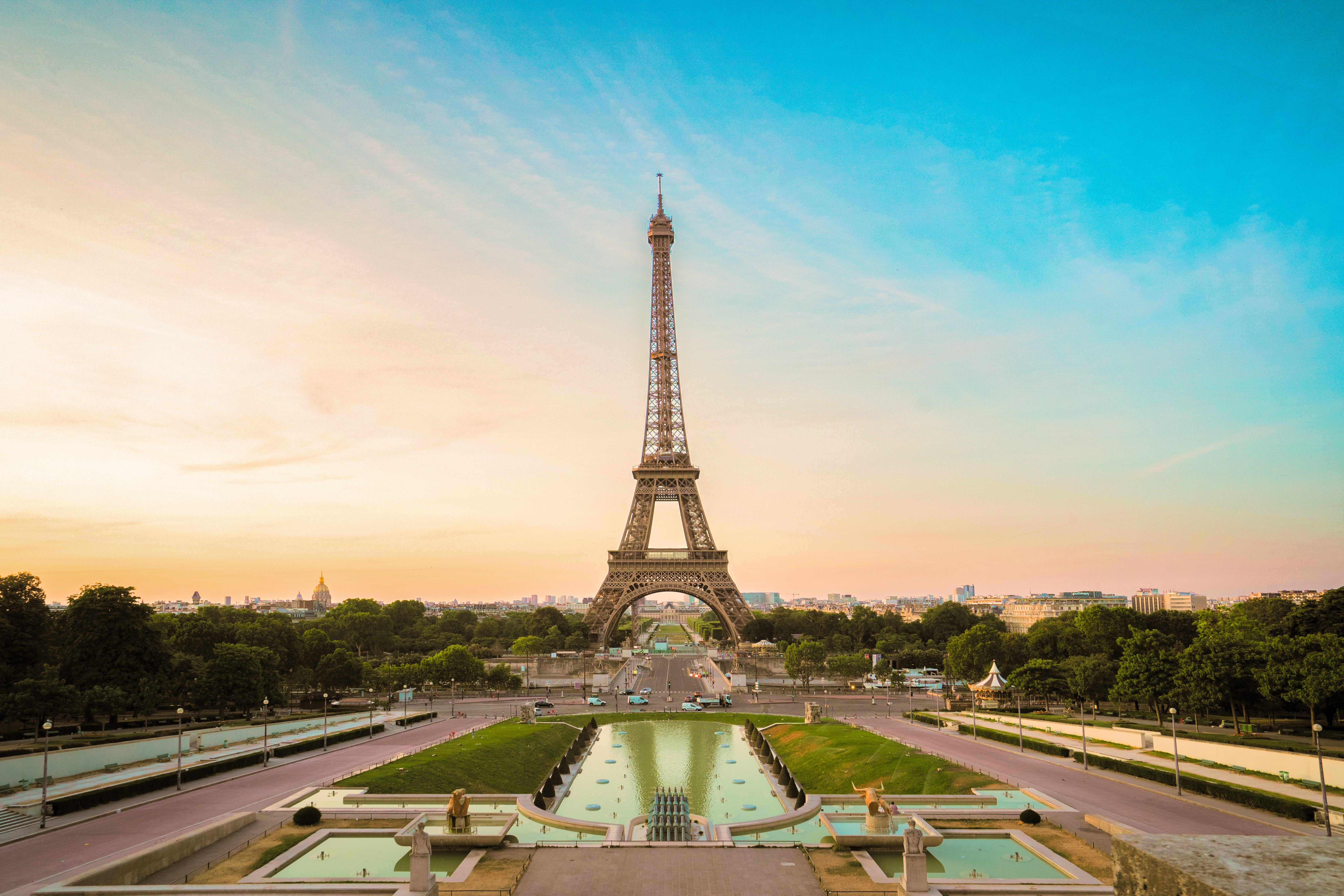 Panoramisk udsigt over Paris med det majestætiske Eiffeltårn og Trocadero-haven i forgrunden ved solnedgang