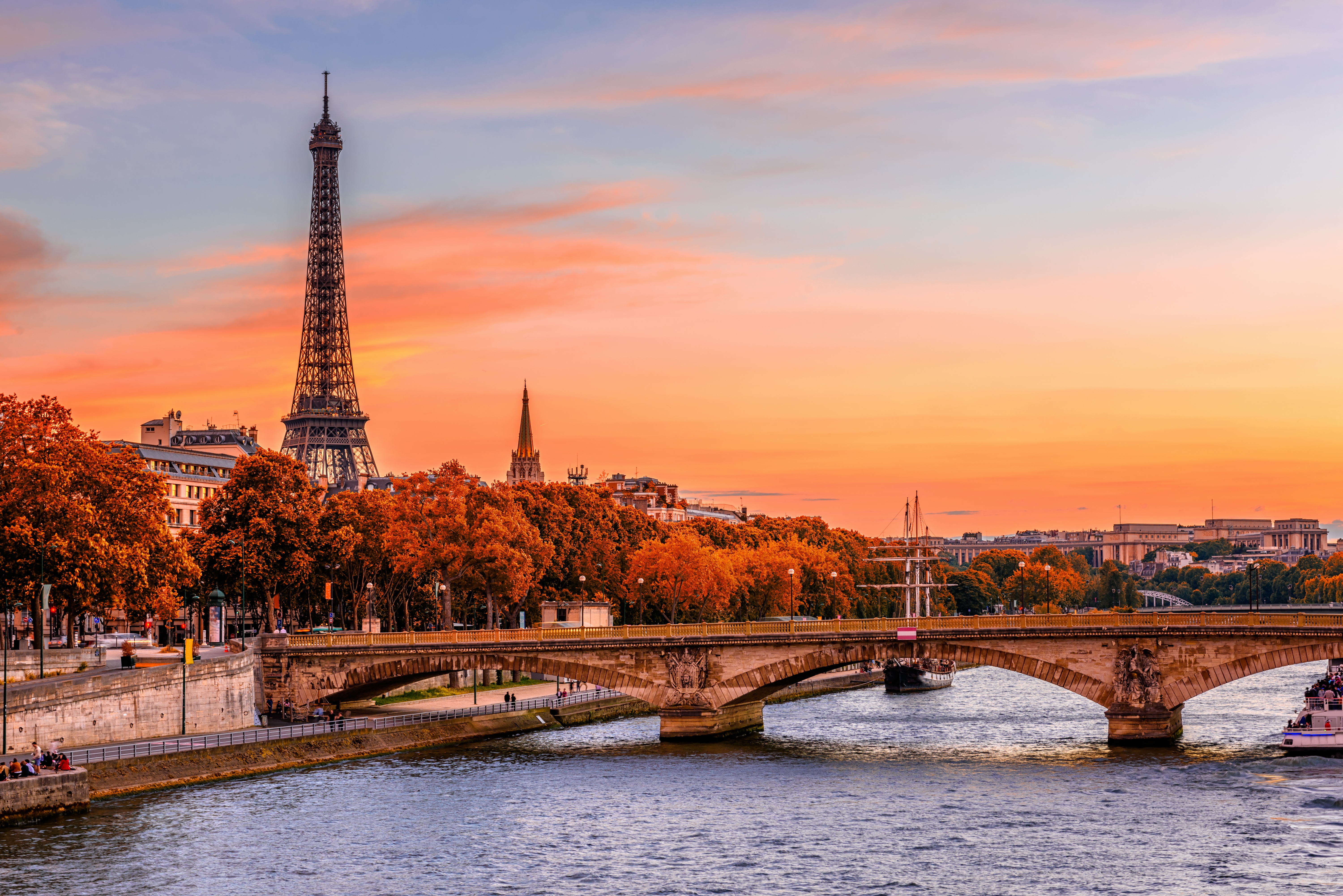 Seine-floden med Eiffeltårnet i baggrunden og stenbroen i Paris' efterårsstemning