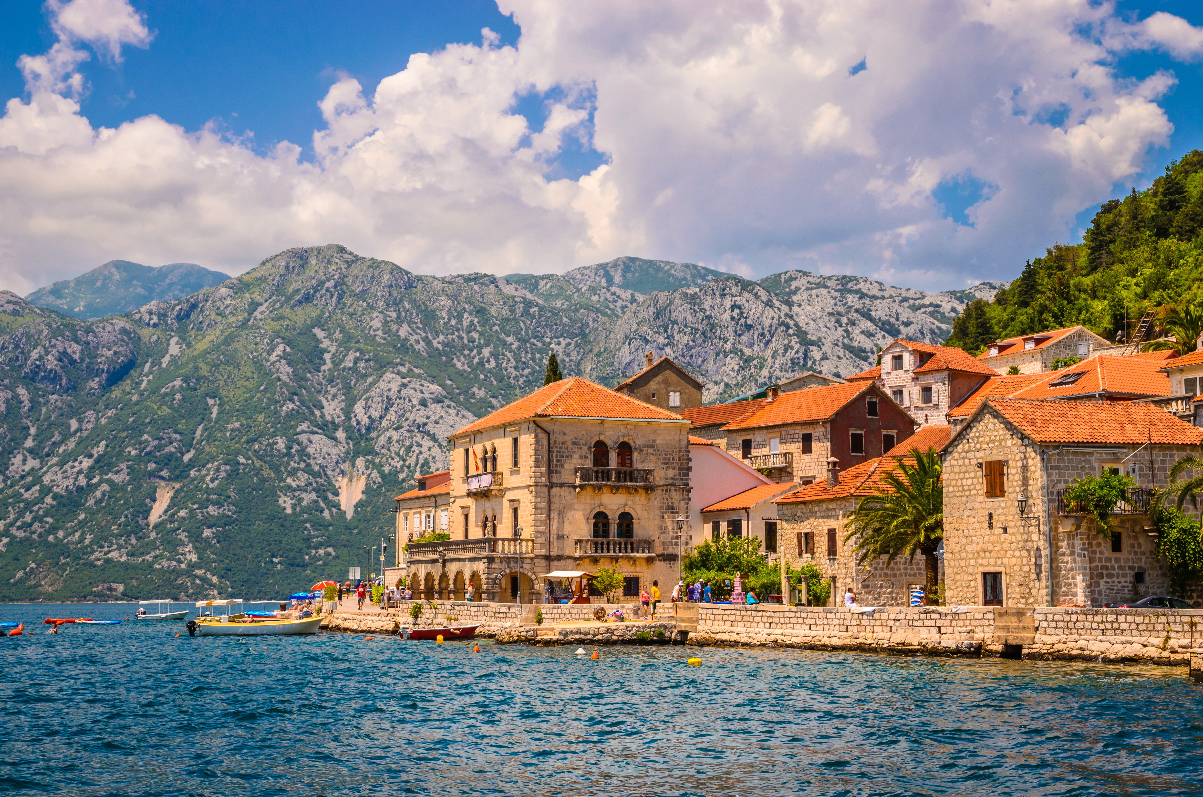 Traditionel stenarkitektur i Perast, Montenegro ved fjordlandskab med høje bjerge