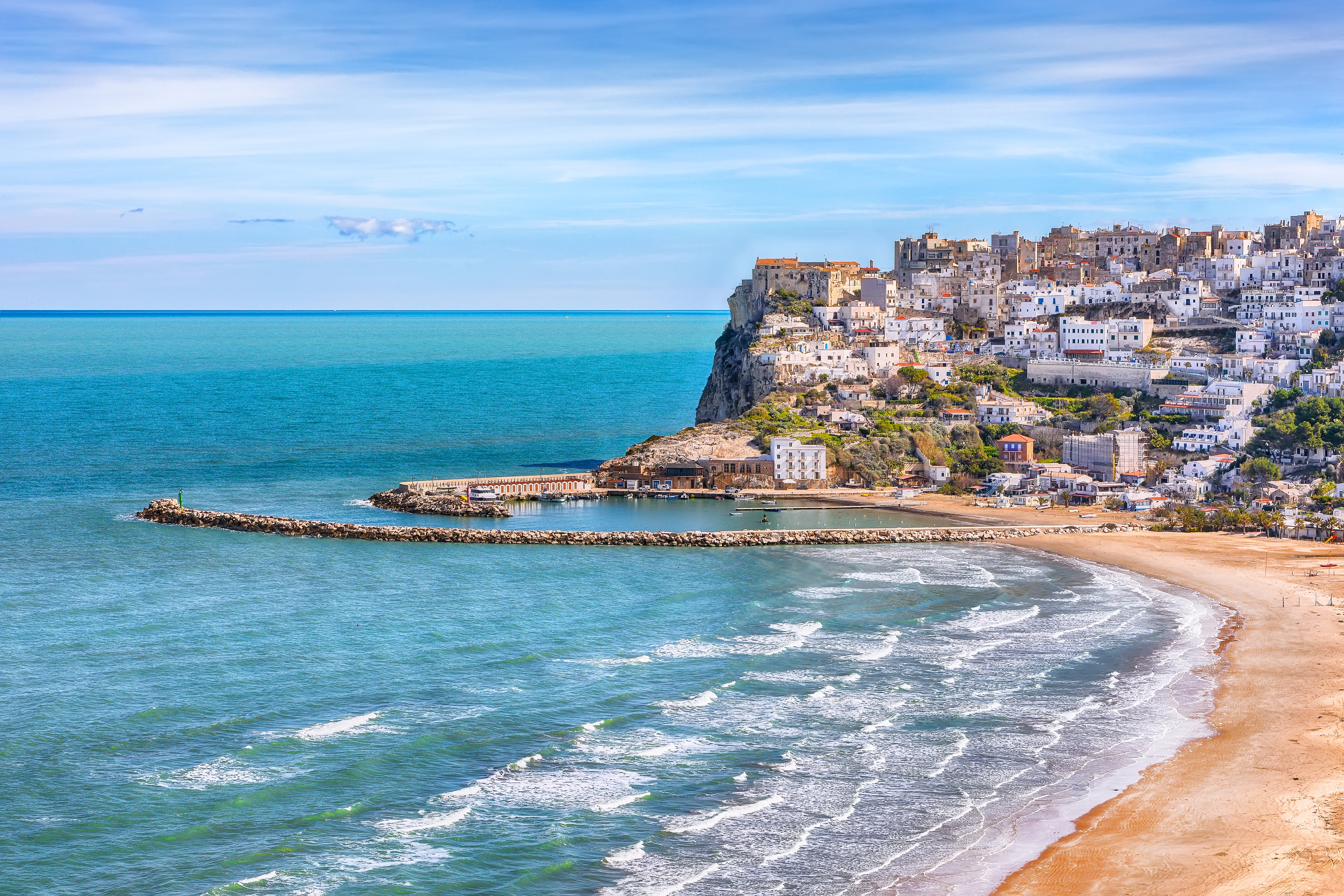 Udsigt over Peschicis hvide huse på dramatiske klippekyster ved Middelhavet i Puglia, Italien, med rolig bugt og sandstrand