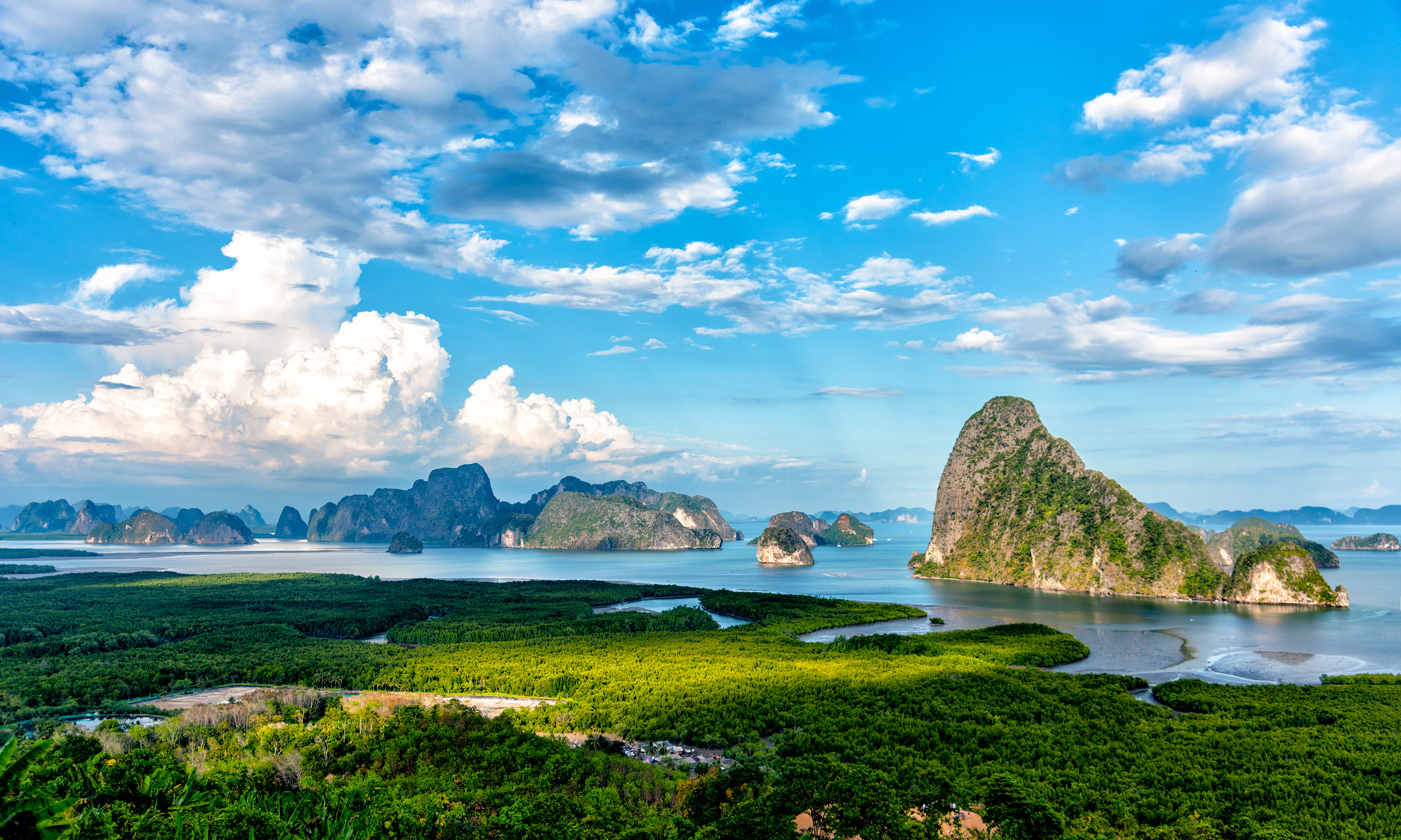 Betagende panoramaudsigt over Phang Nga Bugt i Thailand med grønne kalkstensklippeøer der stikker op af det stille turkisblå hav omgivet af mangrover
