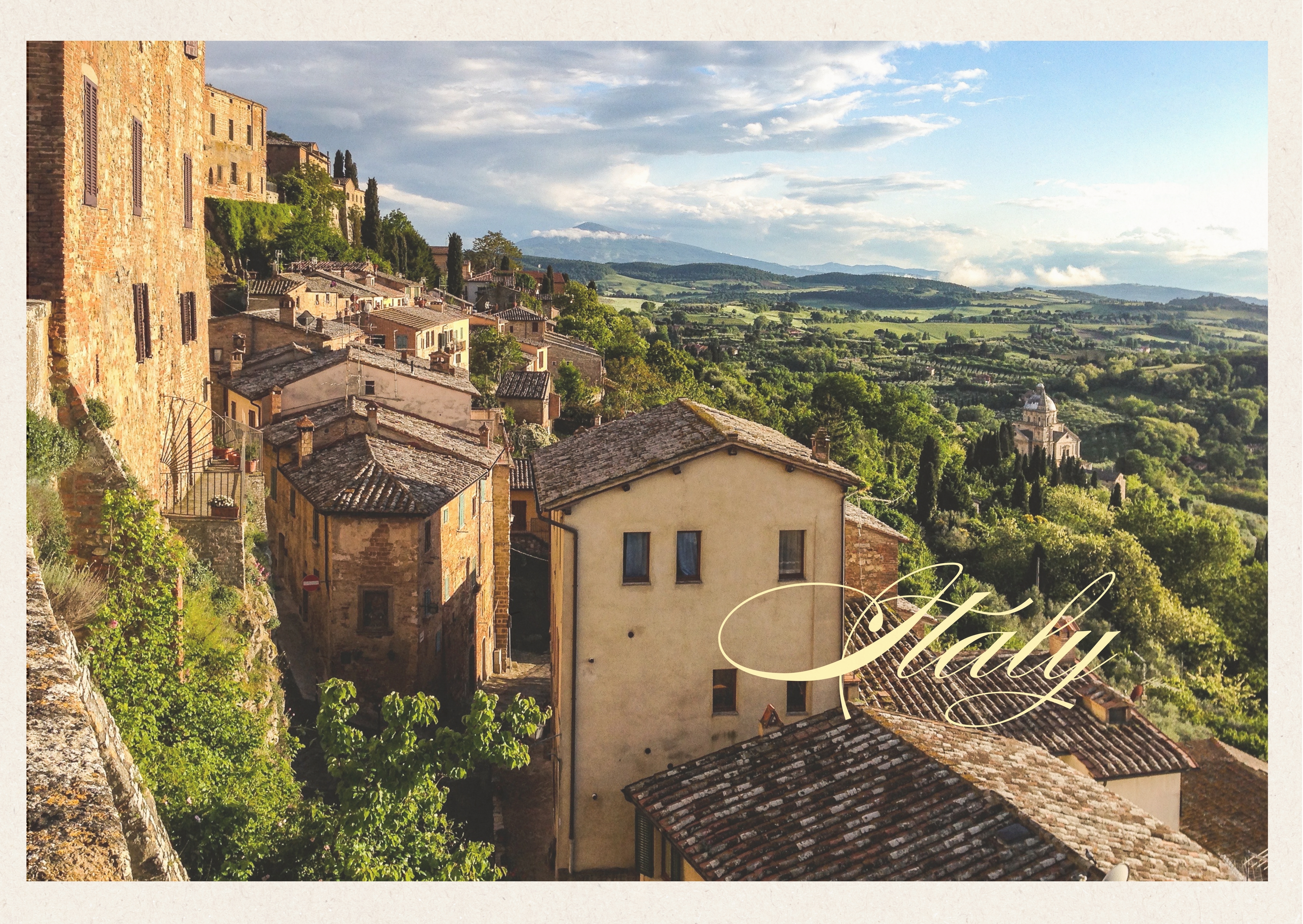 Klassisk italiensk bybillede fra Pienza i Toscana med historiske stenbygninger der kravler ned ad bakkeskråningen mod den frodige toscanske dal