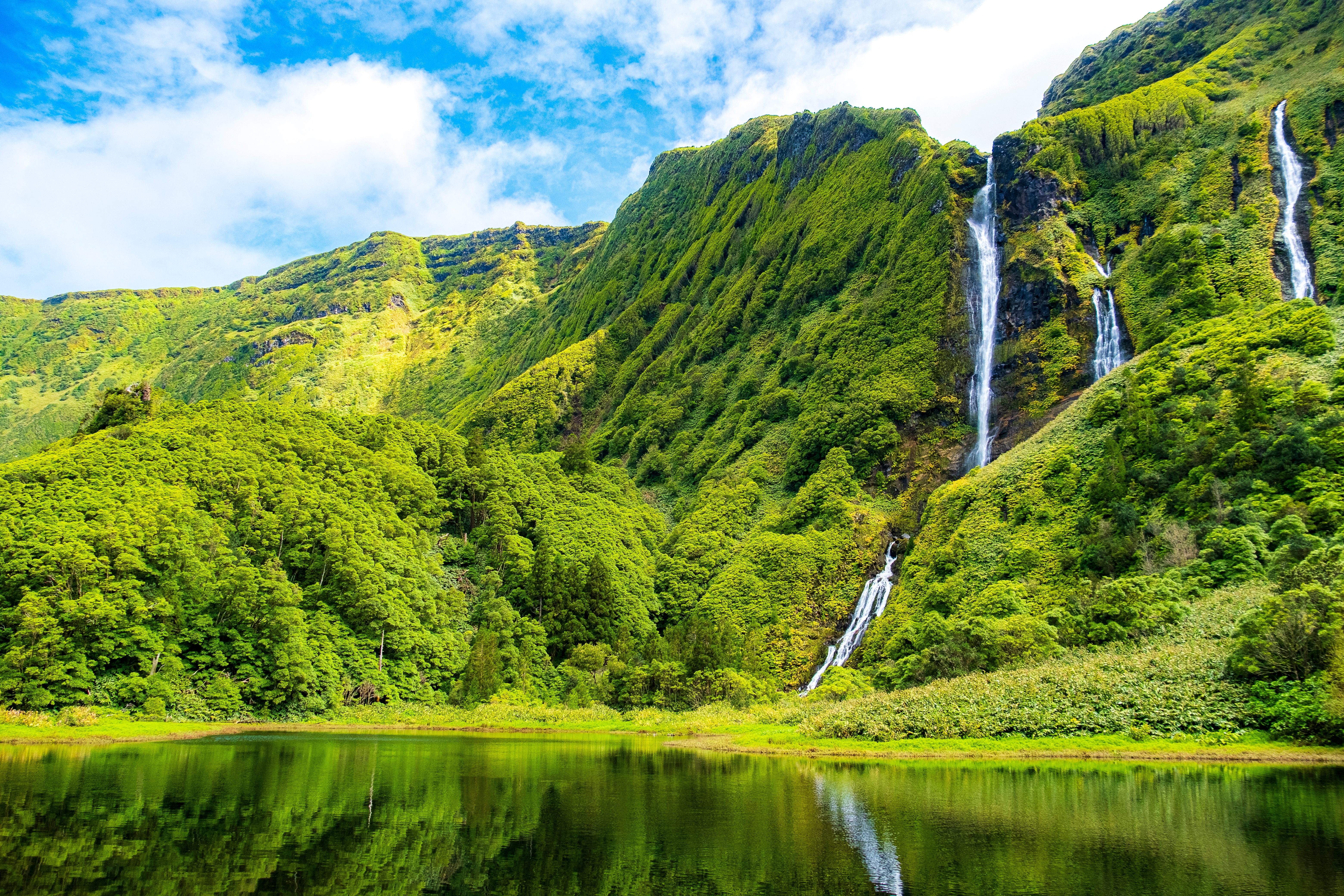 Fantastisk naturoplevelse ved Poço das Alagoinhas med spektakulære vandfald omgivet af frodigt grønt landskab på Flores-øen, Azorerne