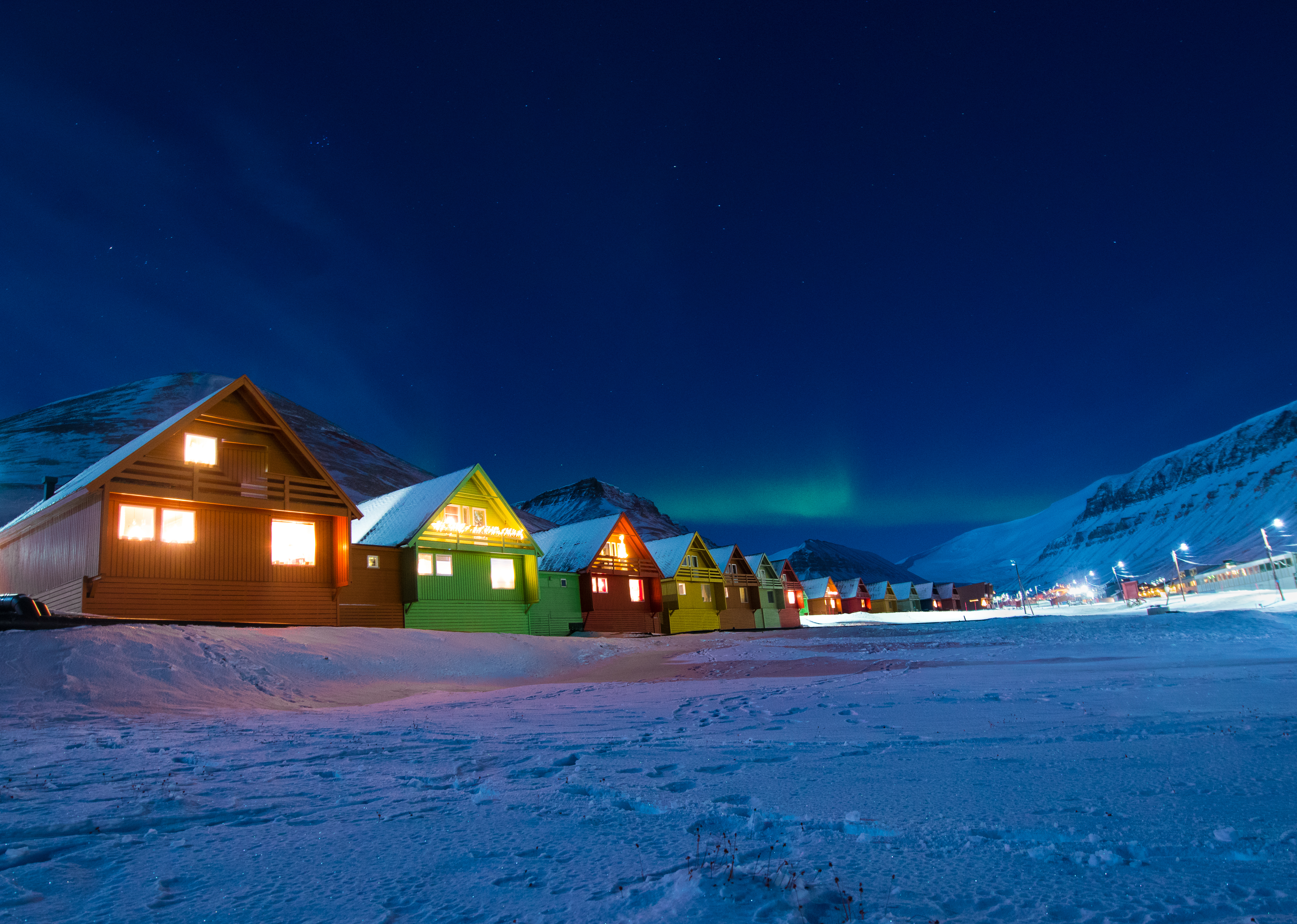 Polarhuse under aurora borealis i Spitsbergen vinter landskab