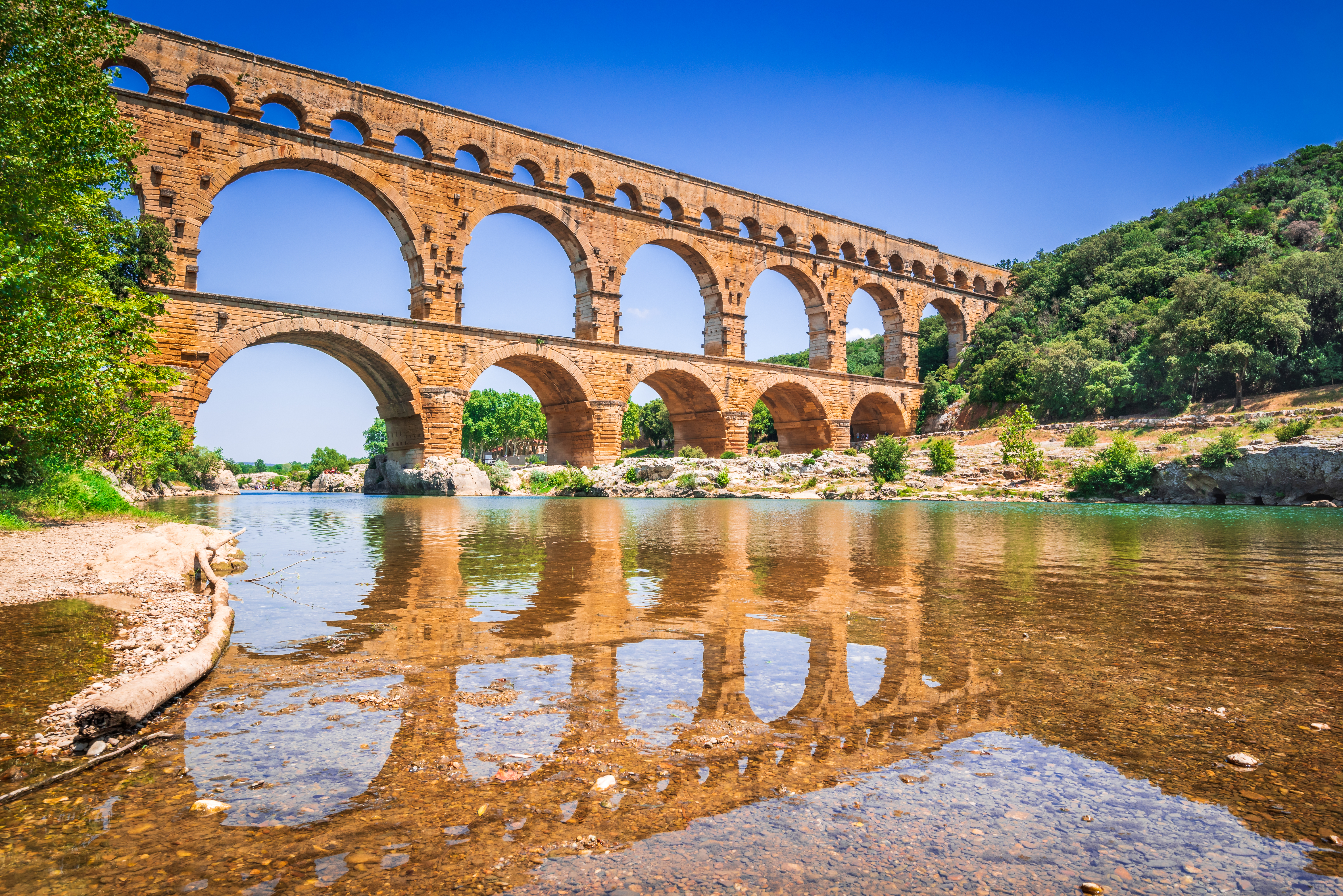 Historiske Pont du Gard akvadukt i det sydlige Frankrig spejlet i den rolige Gardon-flod