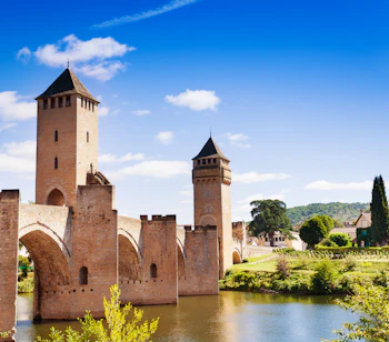 Det smukke Pont Valentré med sine tre tårne over den rolige Lot-flod i Cahors, Frankrig