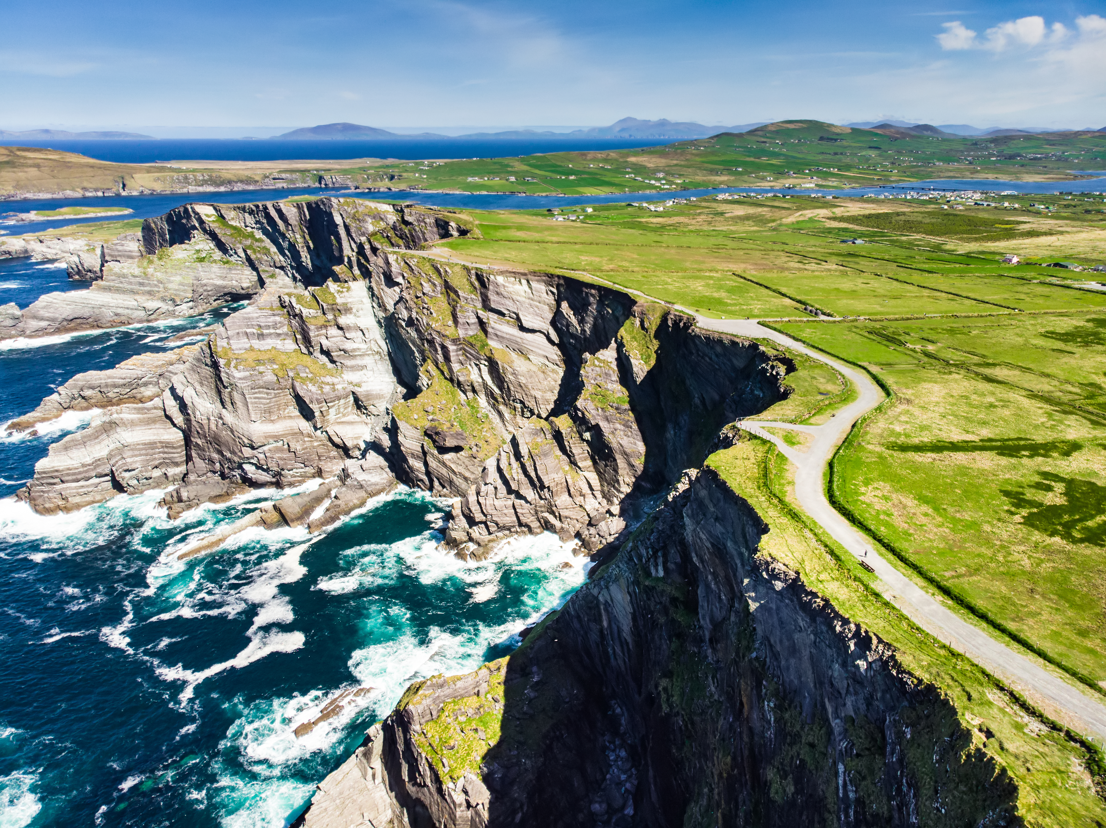 Spektakulær udsigt over de vilde klipper ved Portmagee på Ring of Kerry i Irland med Atlanterhavet og Skellig Islands i baggrunden