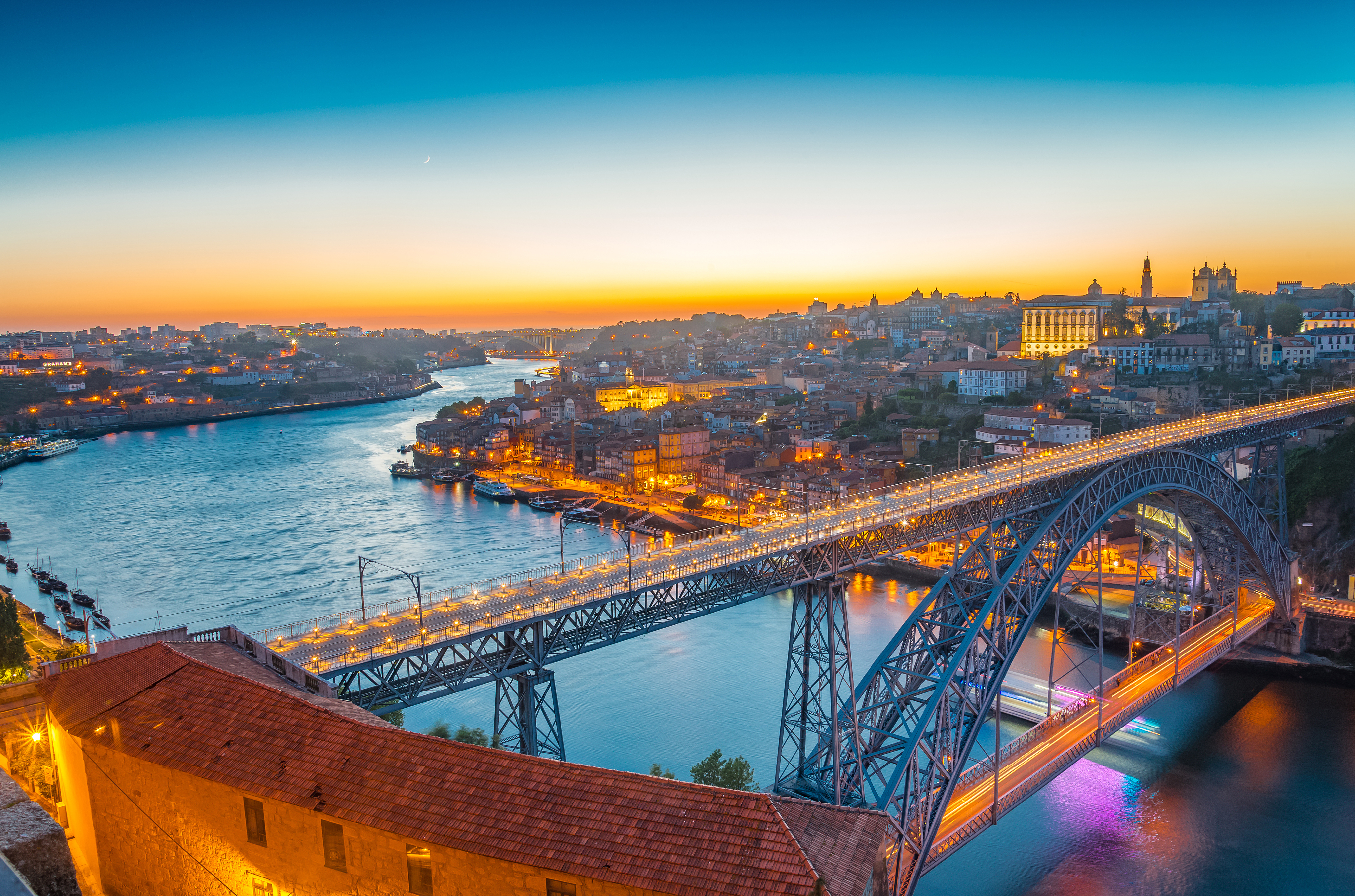 Romantisk aftenbillede af Porto Portugal med den ikoniske Dom Luis I bro og oplyst bydel