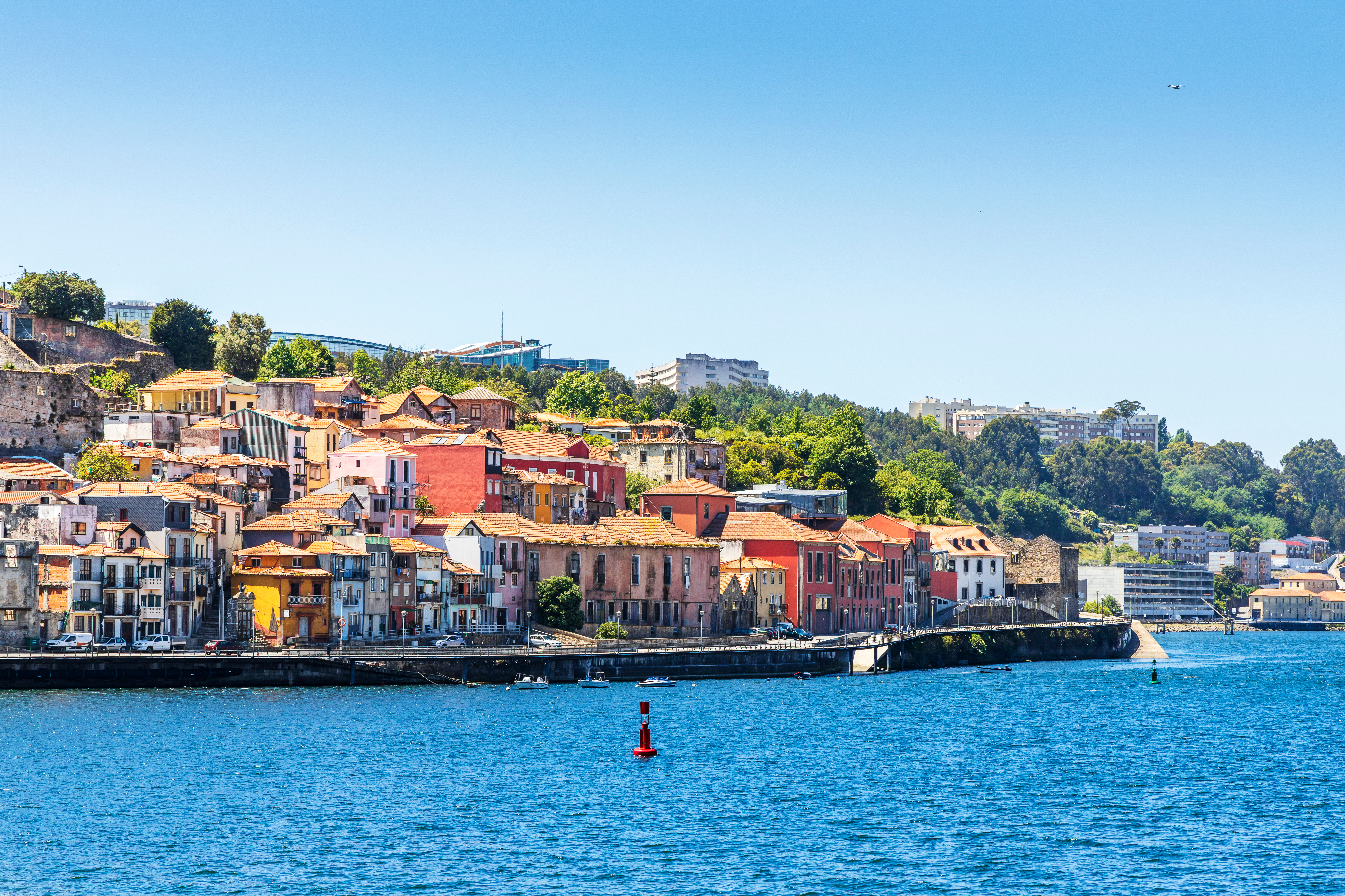 Panoramaudsigt over de farverige historiske bygninger i Vila Nova de Gaia langs Douro-floden i Porto, Portugal under en solrig sommerdag