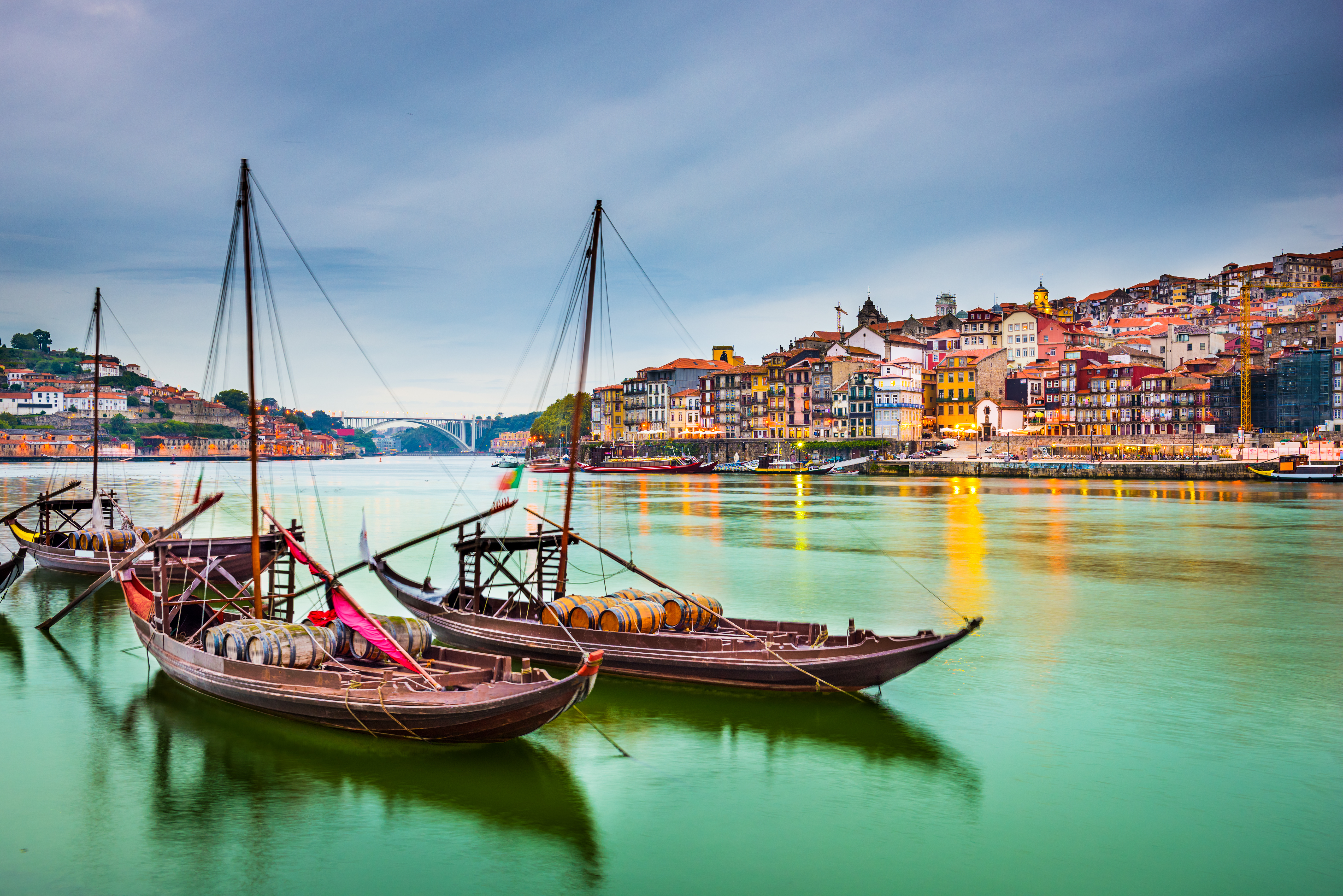 Malerisk udsigt over Portos gamle bydel ved Douro-floden med traditionelle Rabelo-både og farverige historiske bygninger