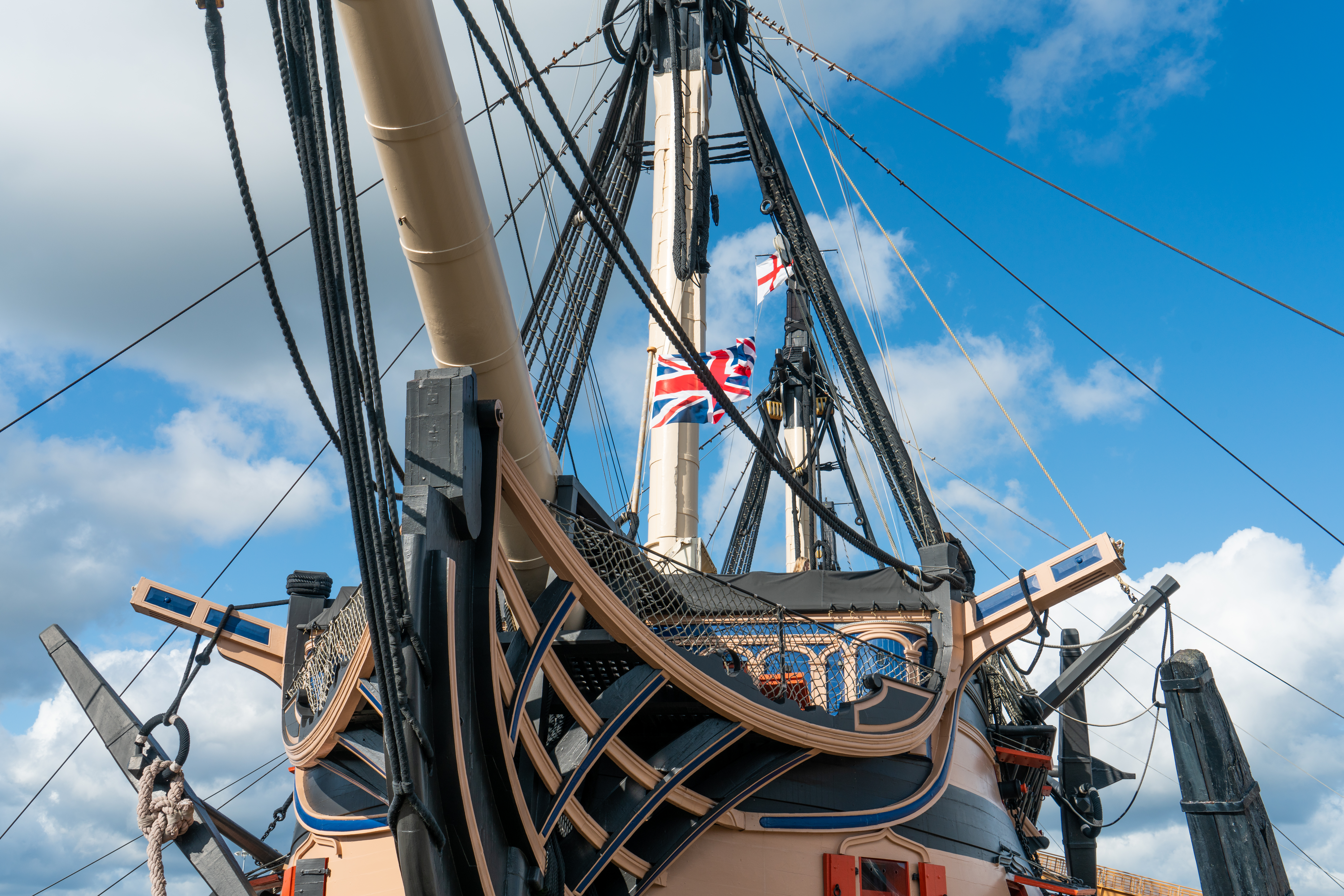 Nærbillede af HMS Victorys bov med Union Jack flag og takkelage ved Portsmouth Historic Dockyard i Hampshire, England