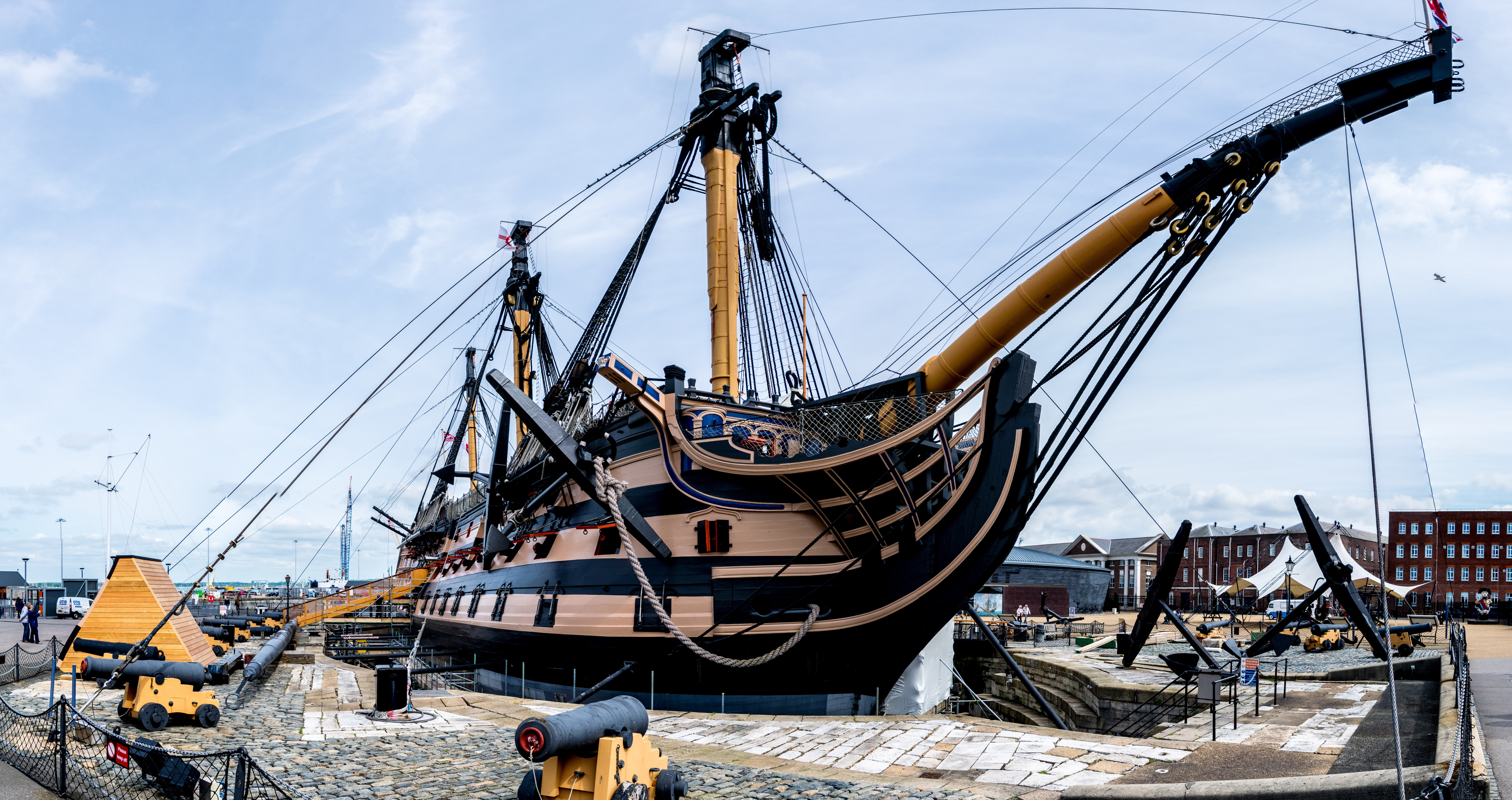 Det historiske HMS Victory krigsskib med kanoner langs siden, bevaret i tørdok ved Portsmouth Historic Dockyard som levende museum i England