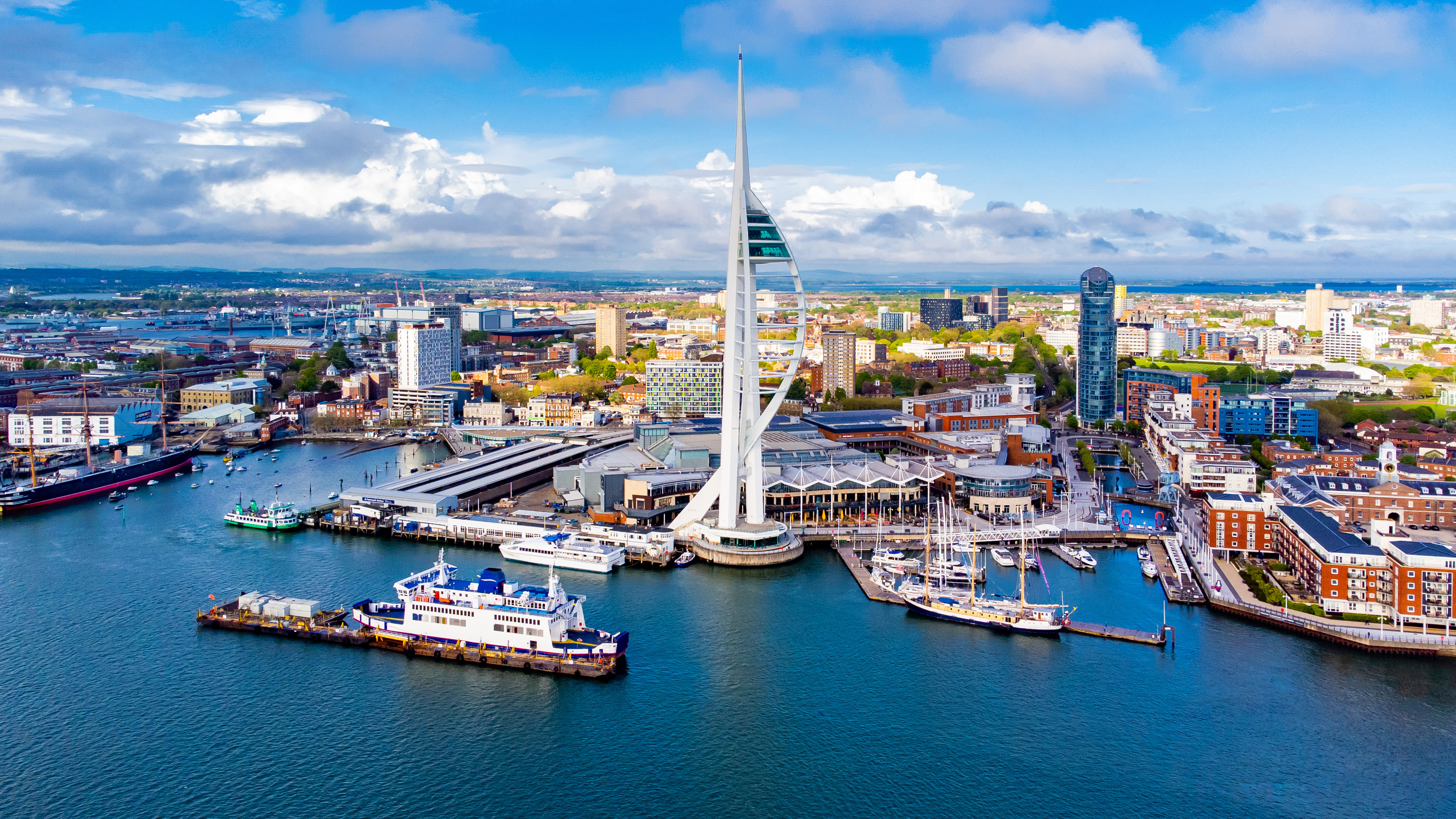 Luftfoto af Portsmouth med det markante Spinnaker Tower ved havnefronten, omgivet af både og moderne bygninger ved den engelske kanal