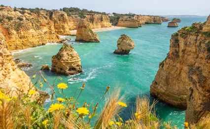 Fantastisk naturskøn kystlinje med gyldne klipper og turkist hav ved Praia da Marinha nær Benagil i Algarve, Portugal