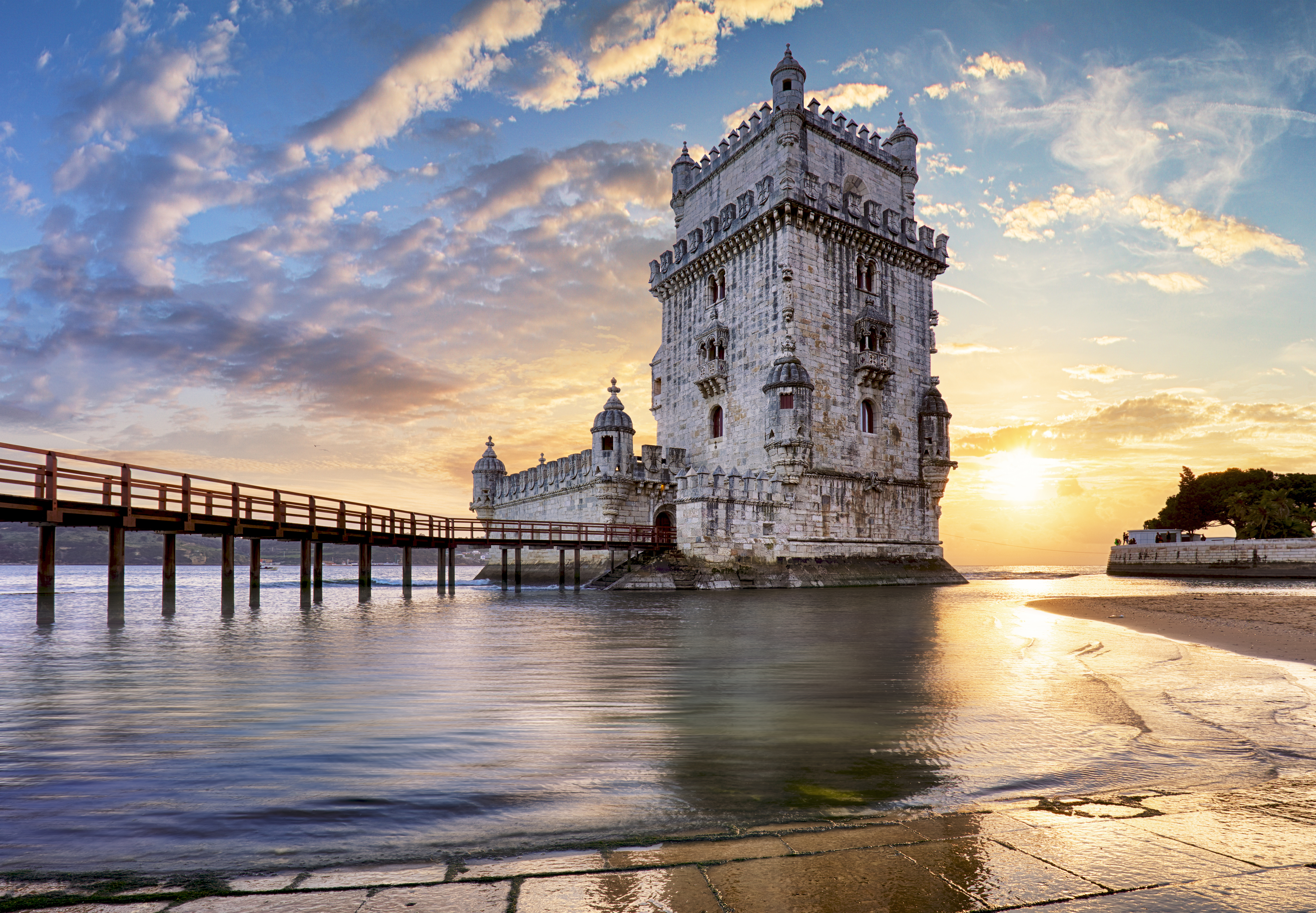 Torre de Belém, Lissabons berømte fæstningstårn fra opdagelsernes tid, fanget i det bløde gyldne lys ved Tagus-flodens bred, et UNESCO-beskyttet monument