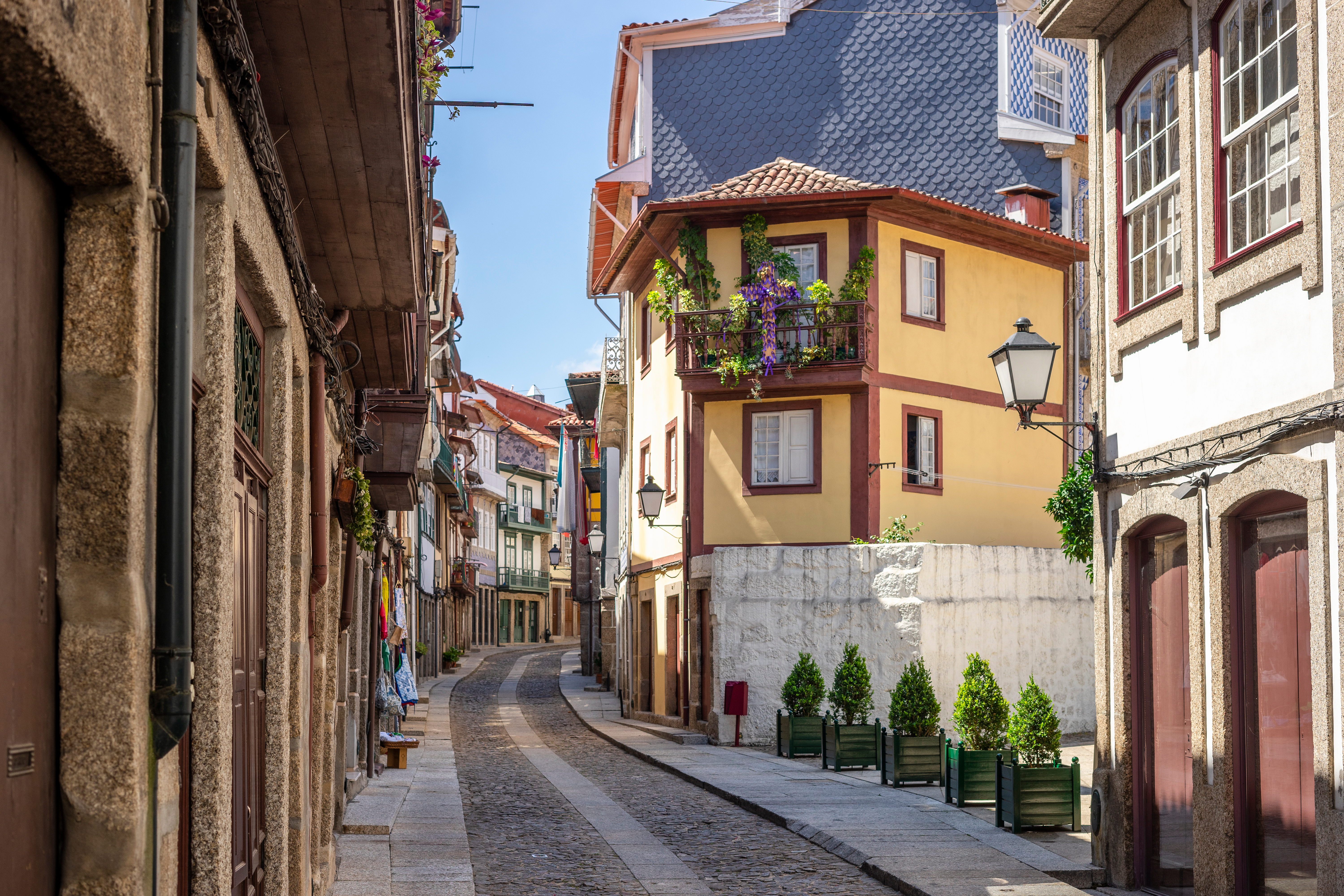 Traditionel portugisisk brostensgade med historiske bygninger i Guimaraes centrum