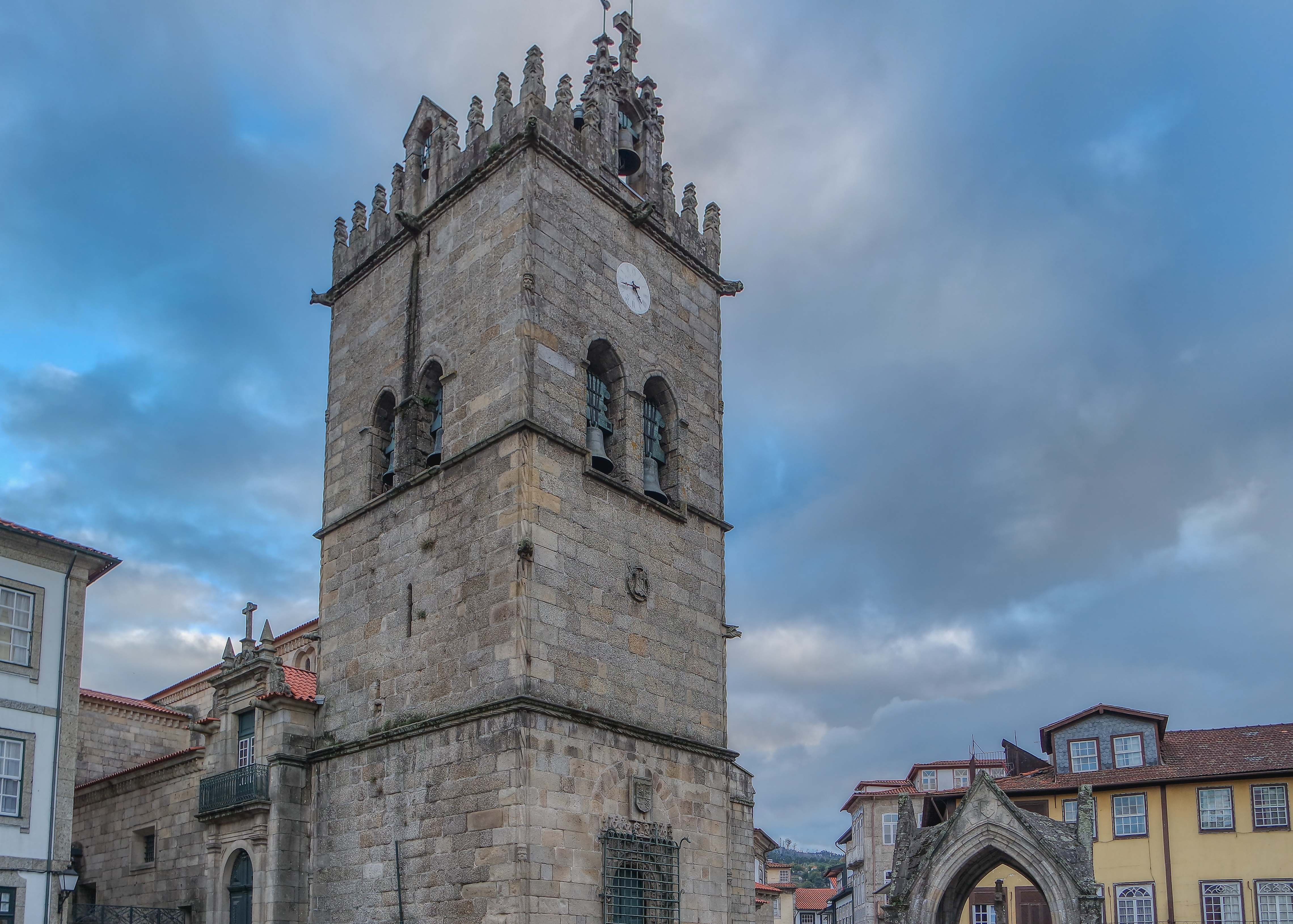 Gotisk klokketårn ved Largo da Oliveira i den historiske by Guimarães i det nordlige Portugal under en dramatisk blå himmel