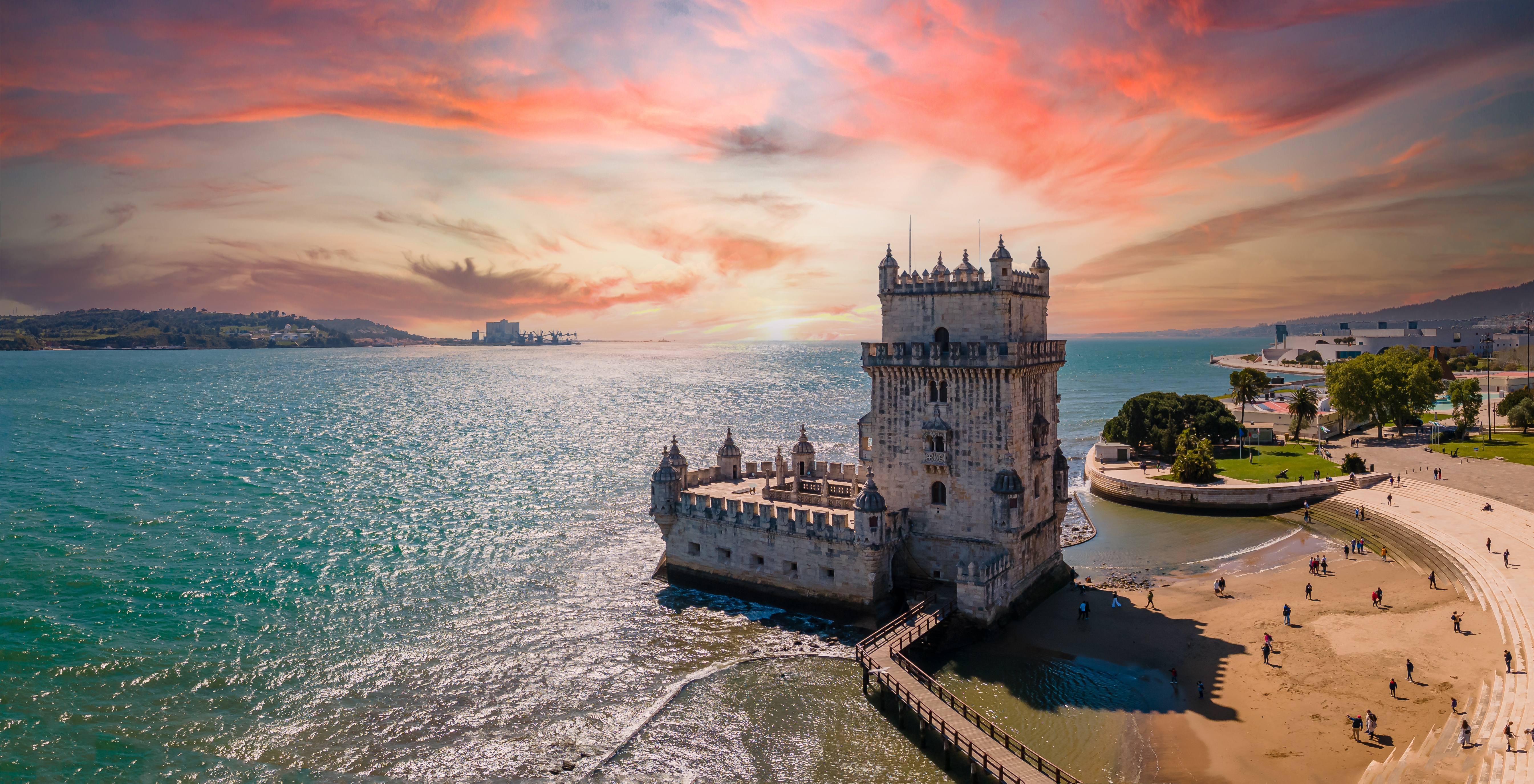 Dronefoto af det majestætiske Belém-tårn ved solnedgangstid i Lissabon - et historisk vartegn og populært rejsemål i Portugal