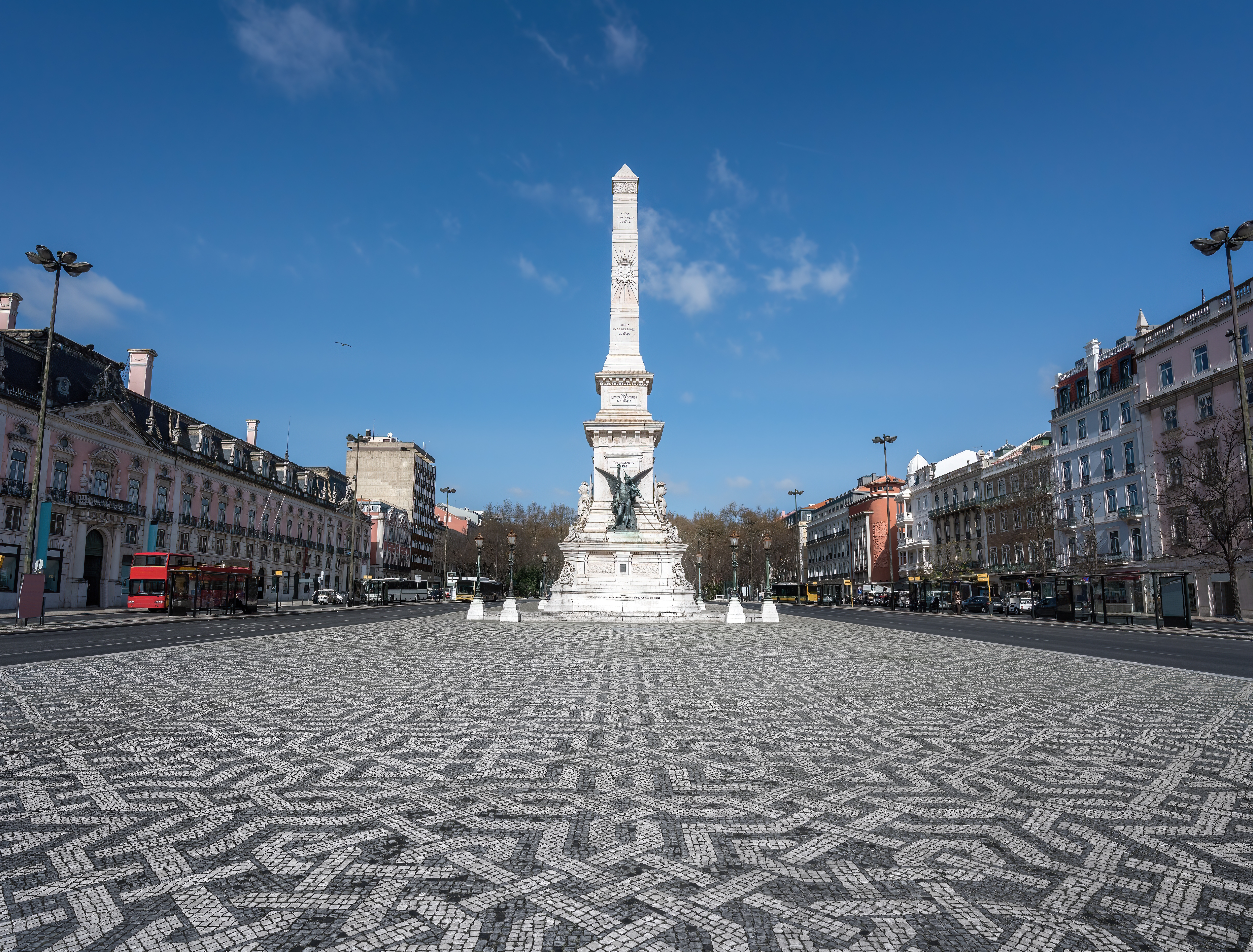 Den historiske Praça dos Restauradores i Lissabon med det smukke hvide monument og den karakteristiske portugisiske brosten-mosaik på pladsen