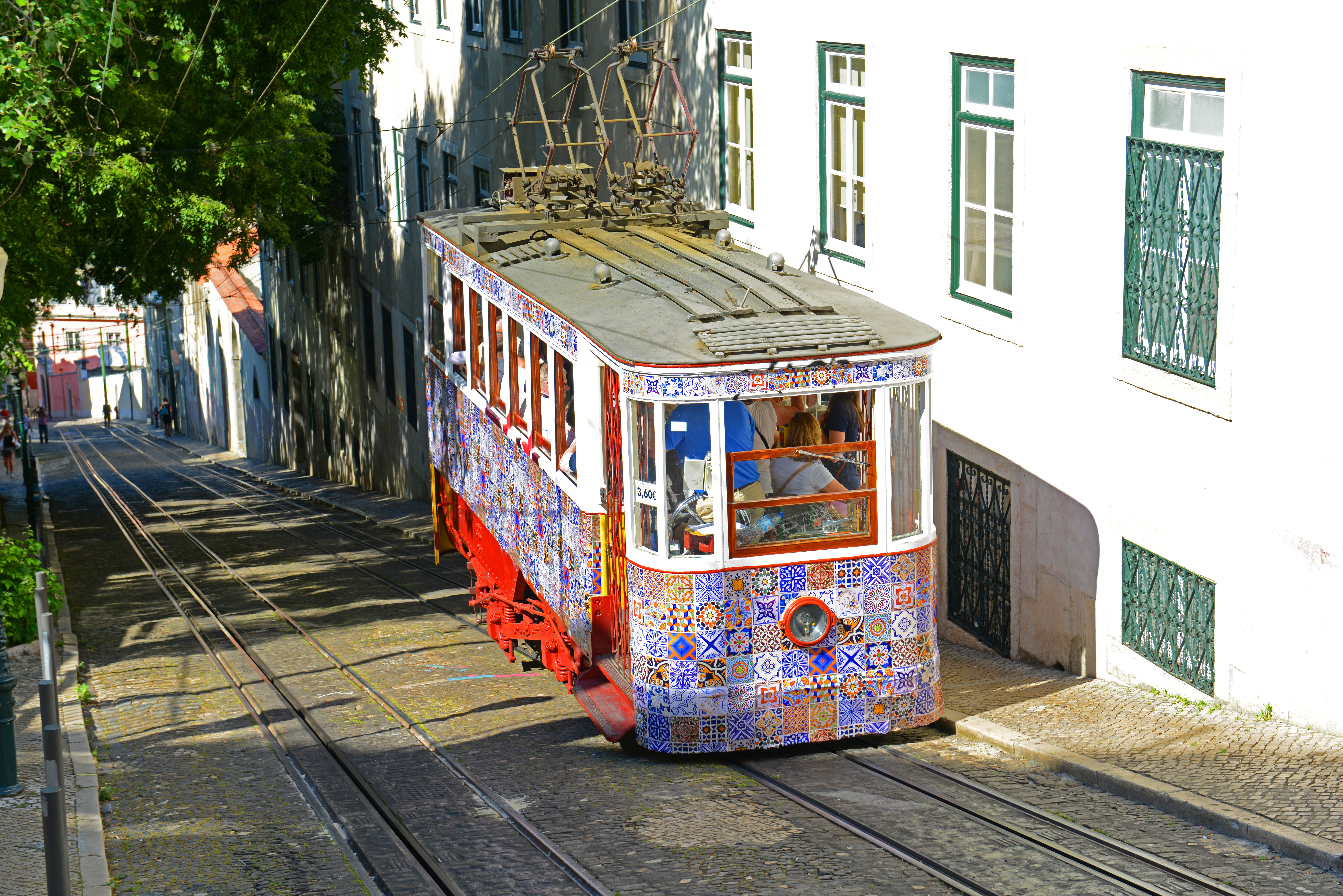 Vintage sporvogn med traditionelle portugisiske fliser kører gennem Lissabons historiske kvarter