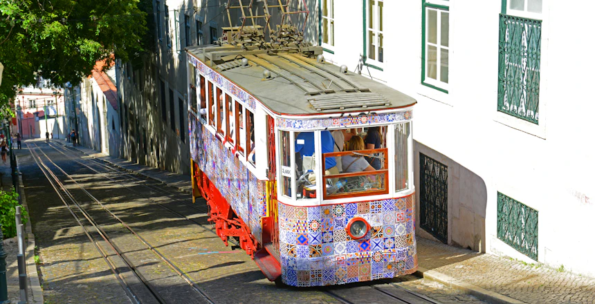 Vintage sporvogn med traditionelle portugisiske fliser kører gennem Lissabons historiske kvarter