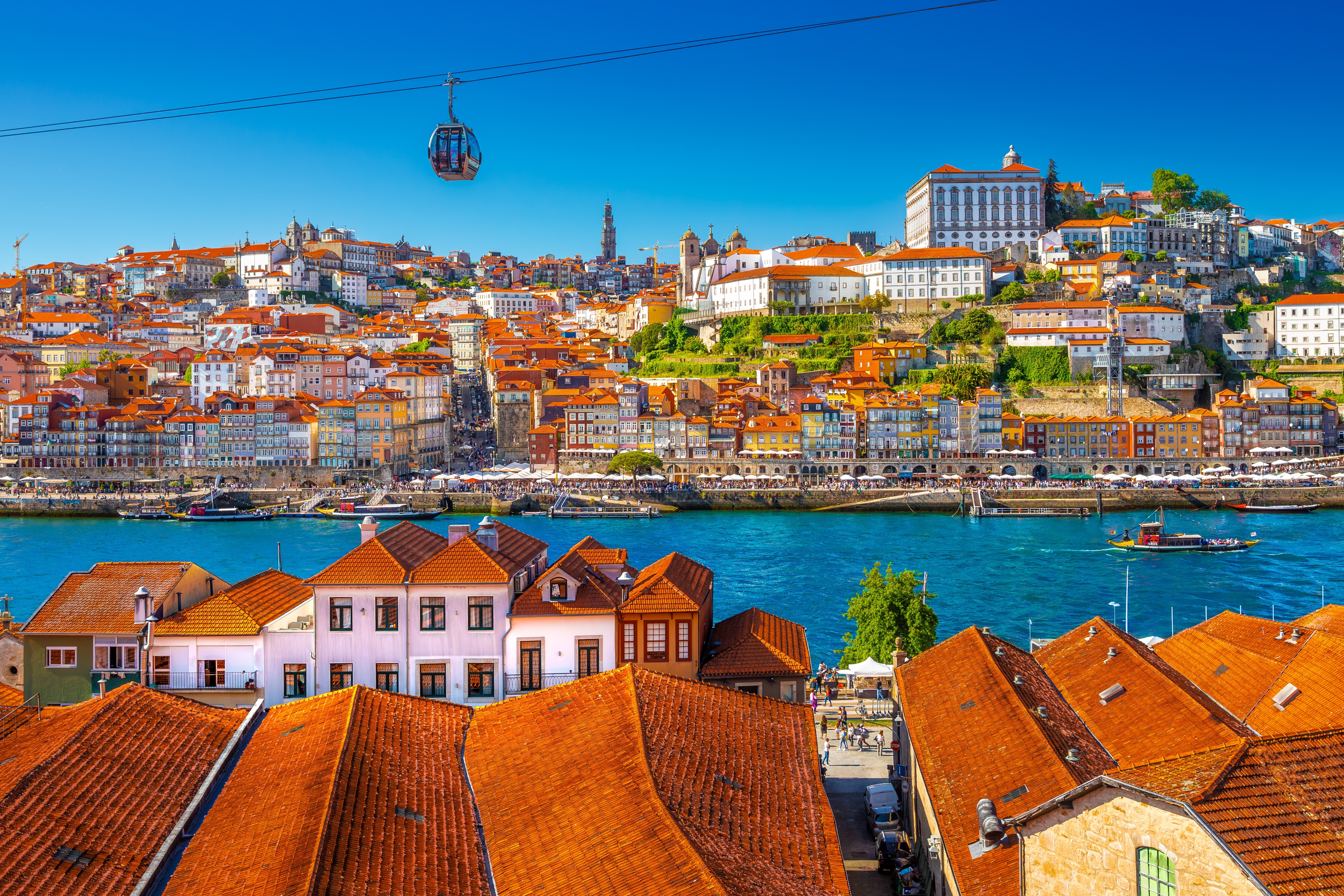 Fascinerende udsigt over kystbyen Porto i Nordportugal med det charmerende bylandskab, den livlige Douro-flod, traditionel arkitektur og den imponerende bro på en strålende sommerdag