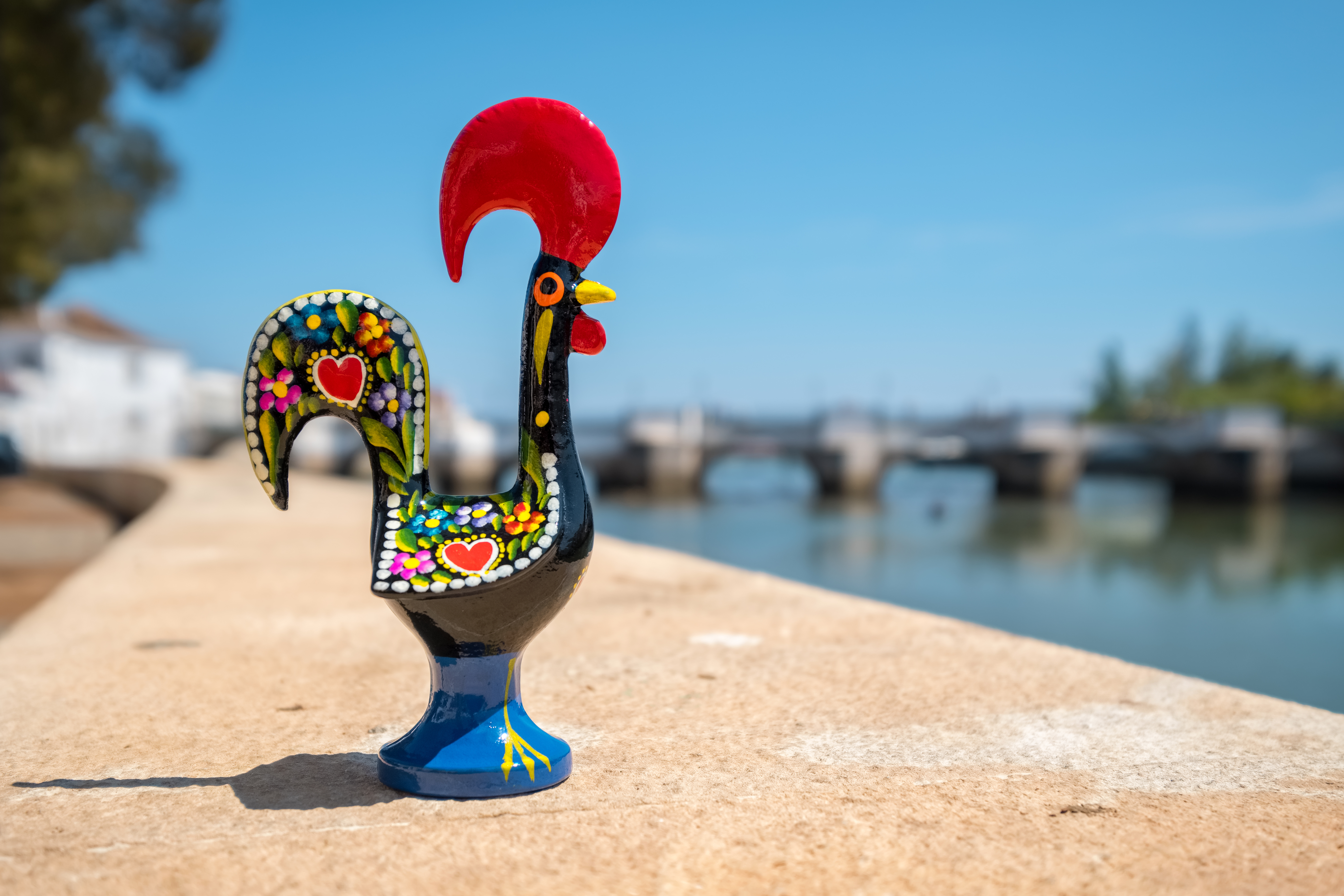 Håndlavet portugisisk keramik hane souvenir ved Tavira med romersk bro i Algarve