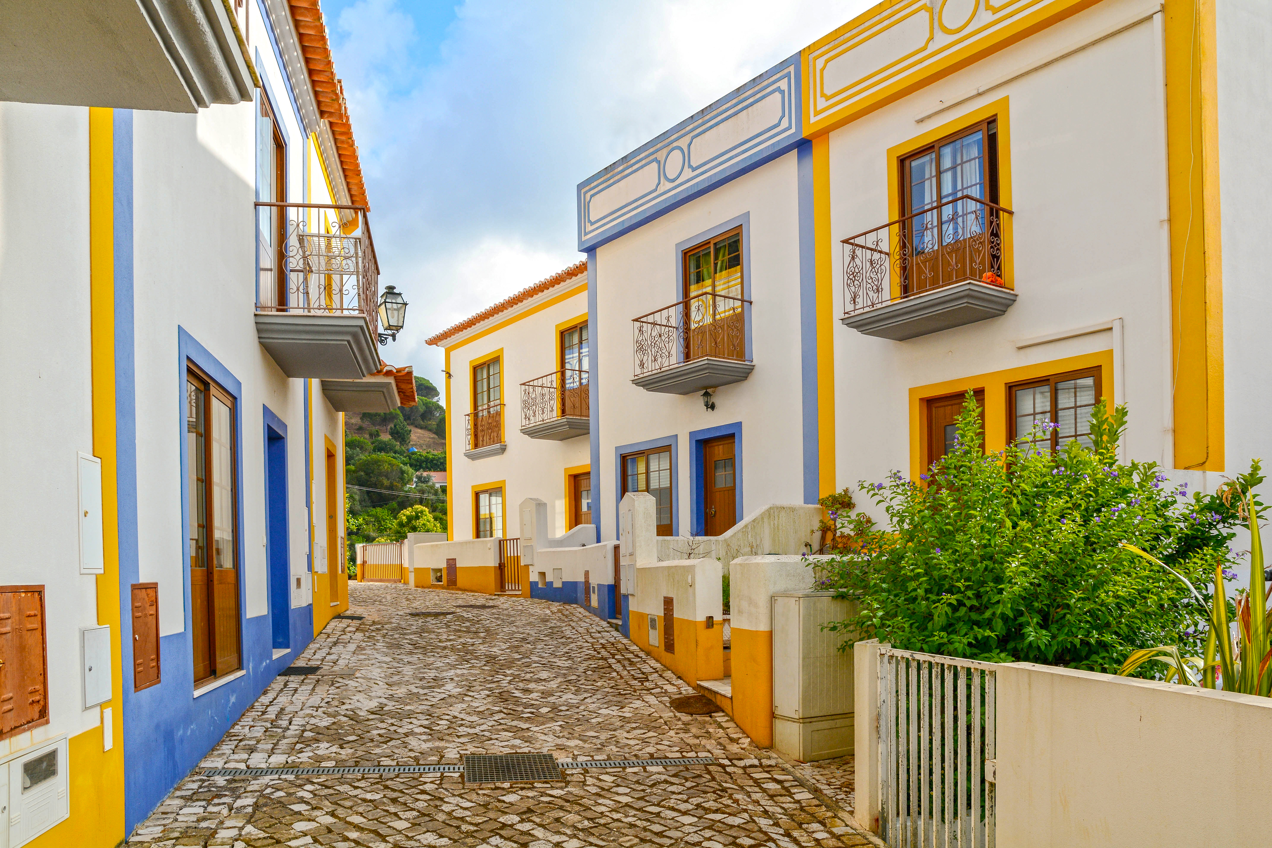 Stemningsfuld brolagt gade med traditionelle portugisiske huse i den historiske landsby Bordeira i Faro-distriktet, Algarve