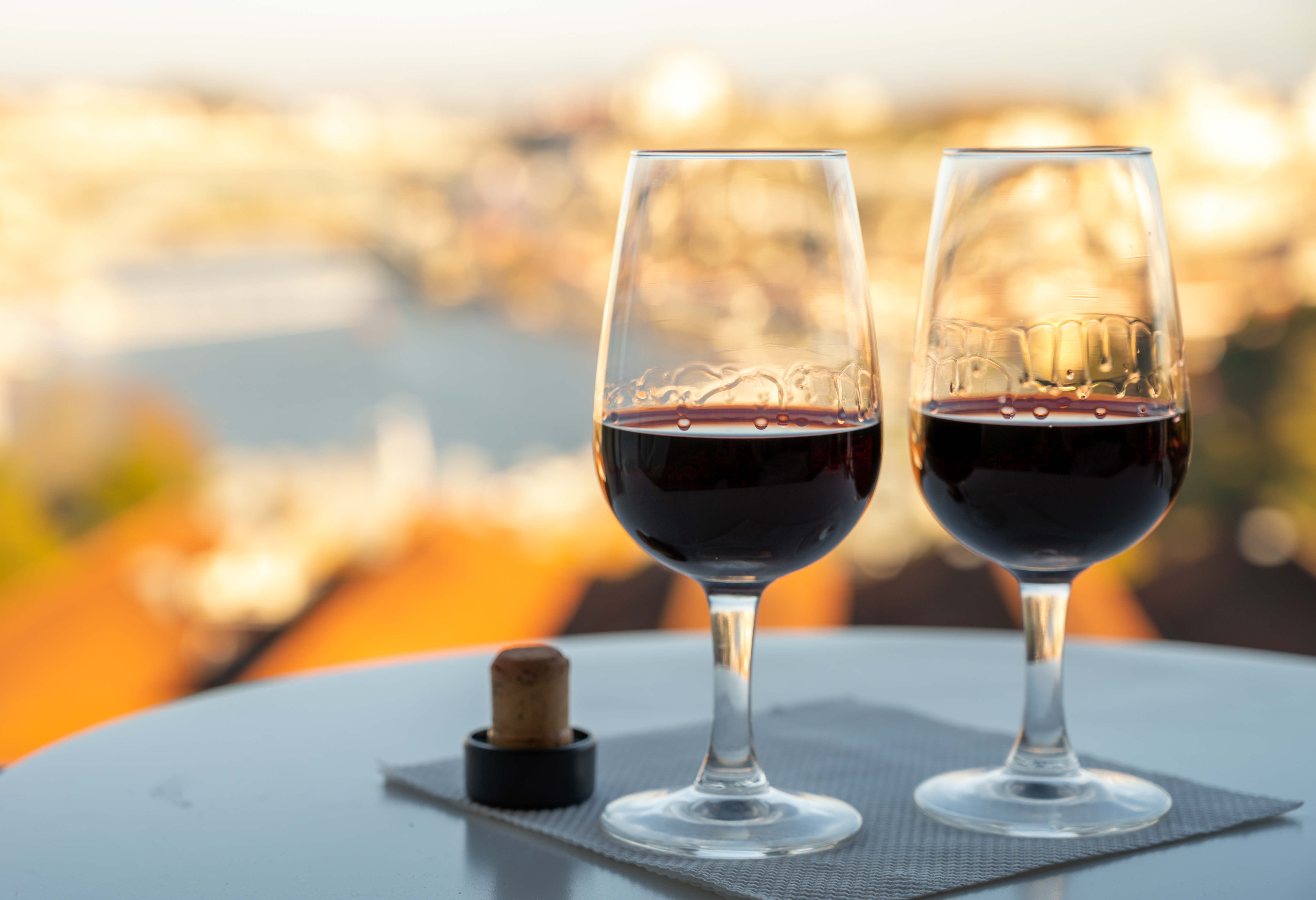 Nyd to glas ruby og tawny portvin på terrasse med smuk udsigt over Porto og Douro-floden ved solnedgang