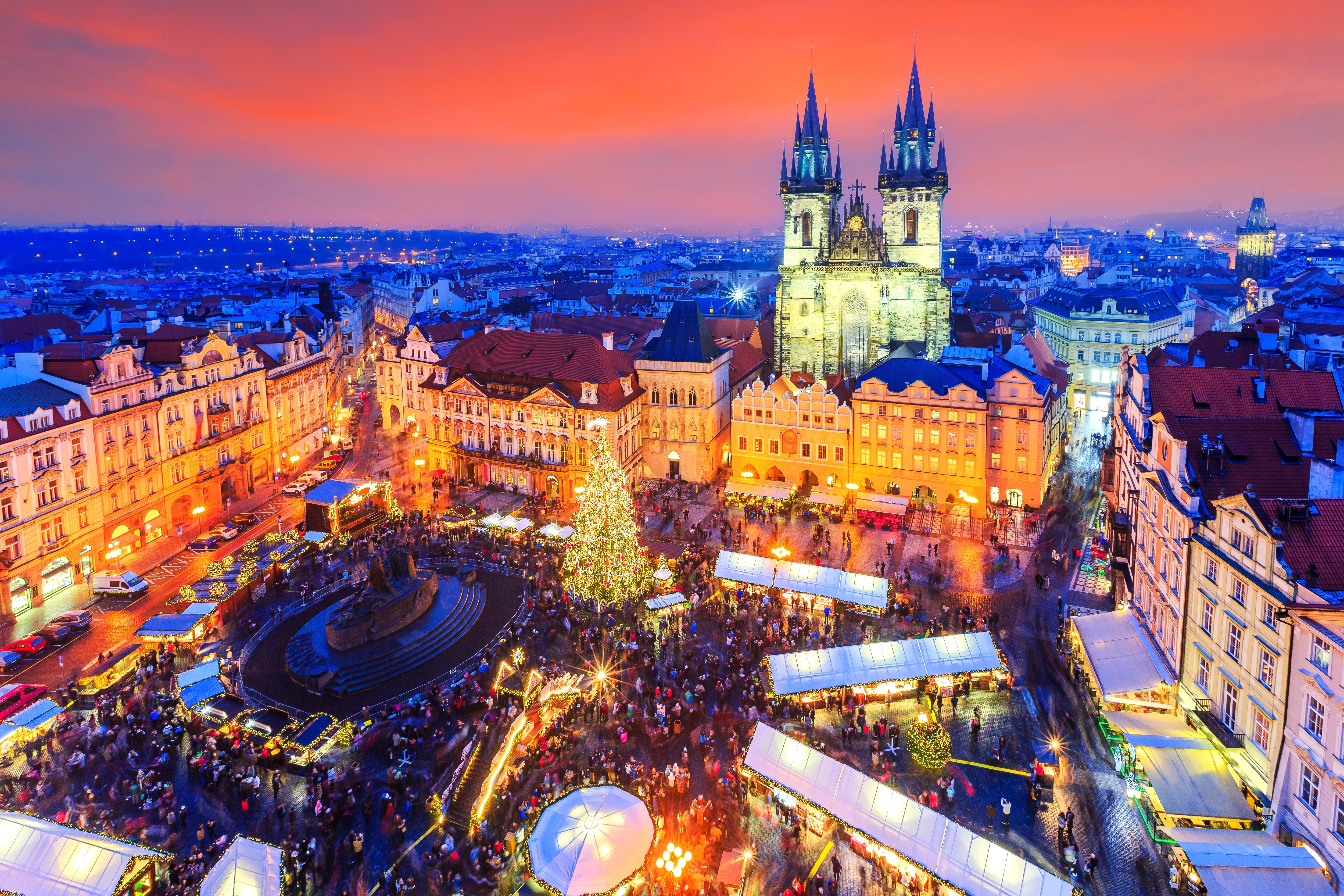 Stemningsfuldt julemarked på Gamle Torv i Prag, Tjekkiet, med oplyst juletræ og Tyn Kirken i aftenlyset