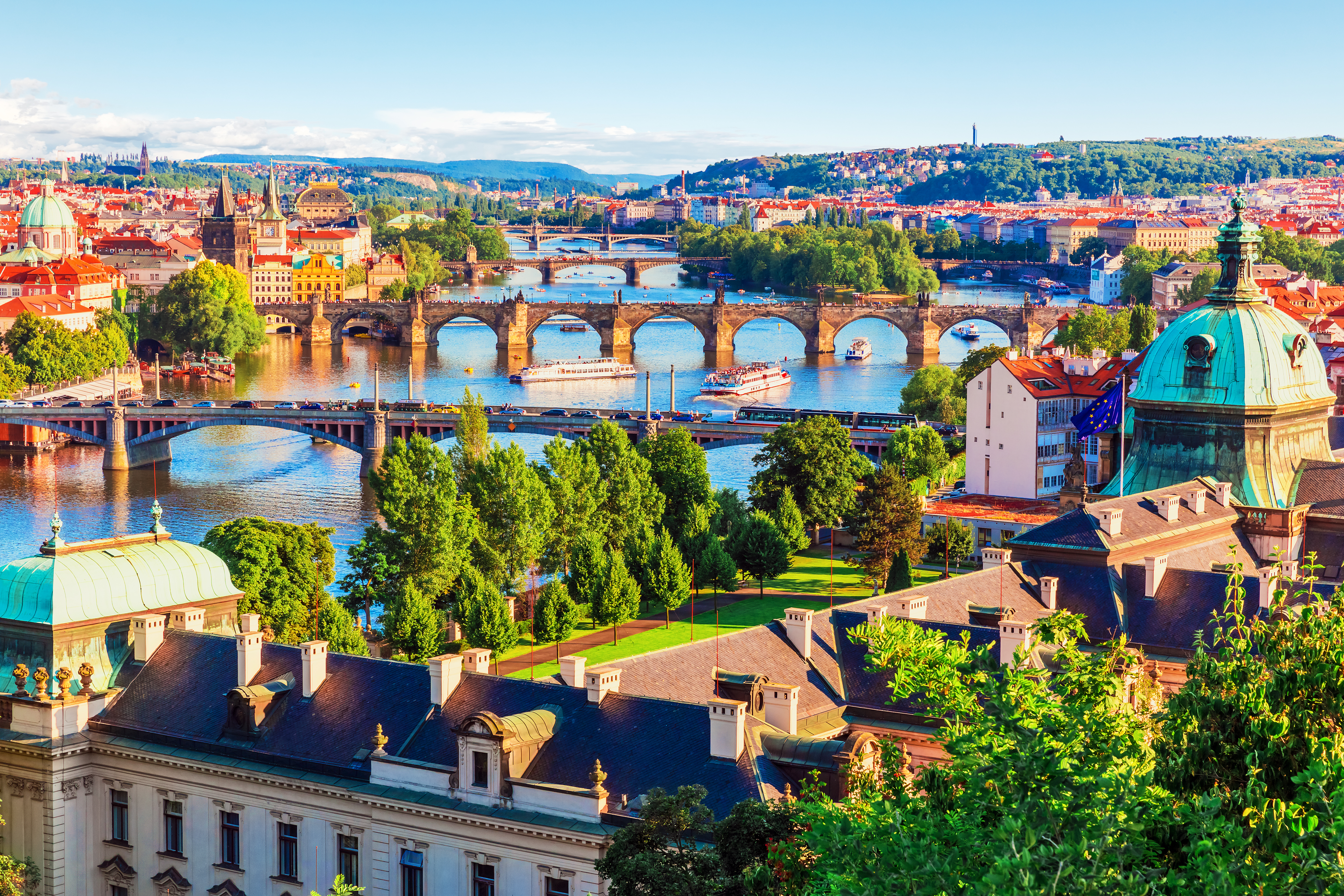 Rejsefoto af Prags maleriske broer over Vltava med farverige tage og kirketårne