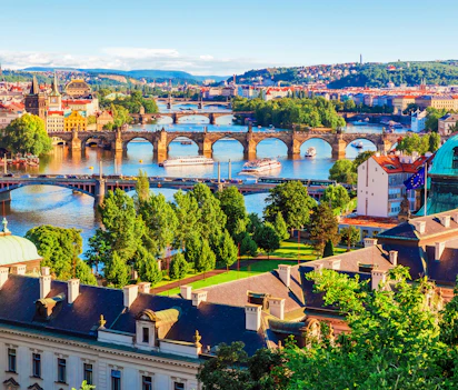 Rejsefoto af Prags maleriske broer over Vltava med farverige tage og kirketårne