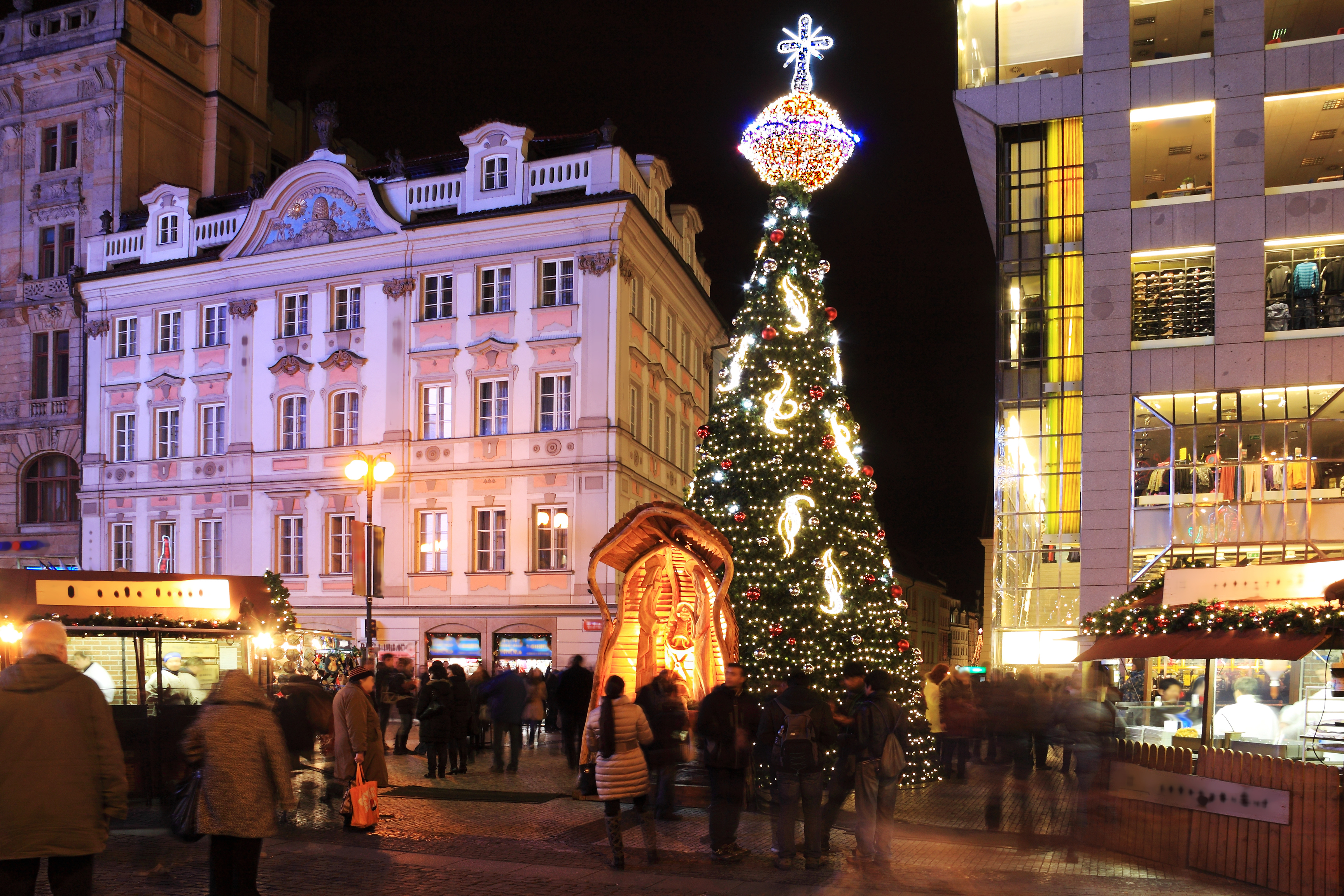 Vinterjulemarked i Prags historiske centrum med oplyst juletræ og gamle bygninger