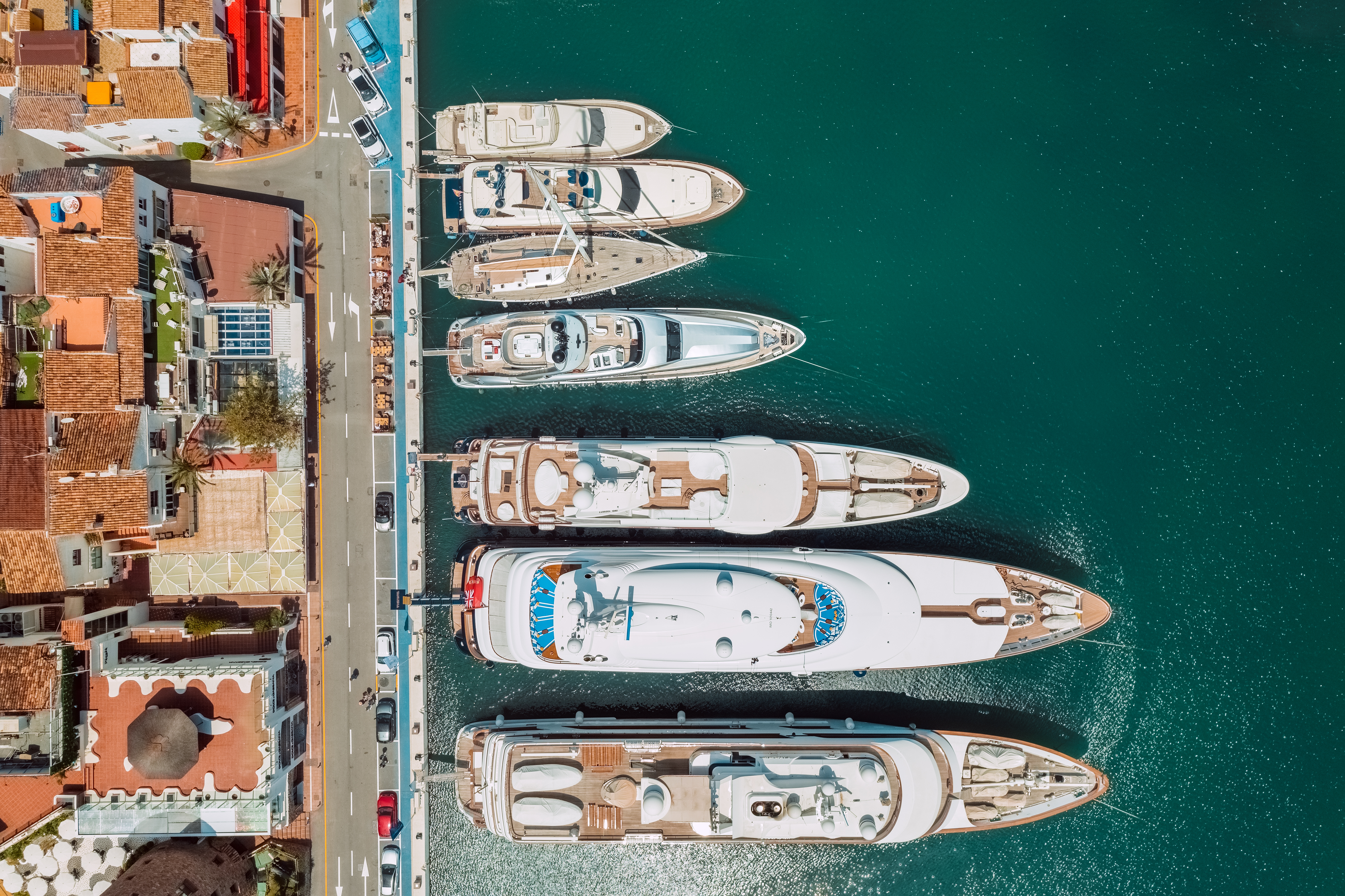 Drone-foto af dyre luksusyachts i Puerto Banus havn i Marbella, Spanien, omgivet af blåt middelhavsvand