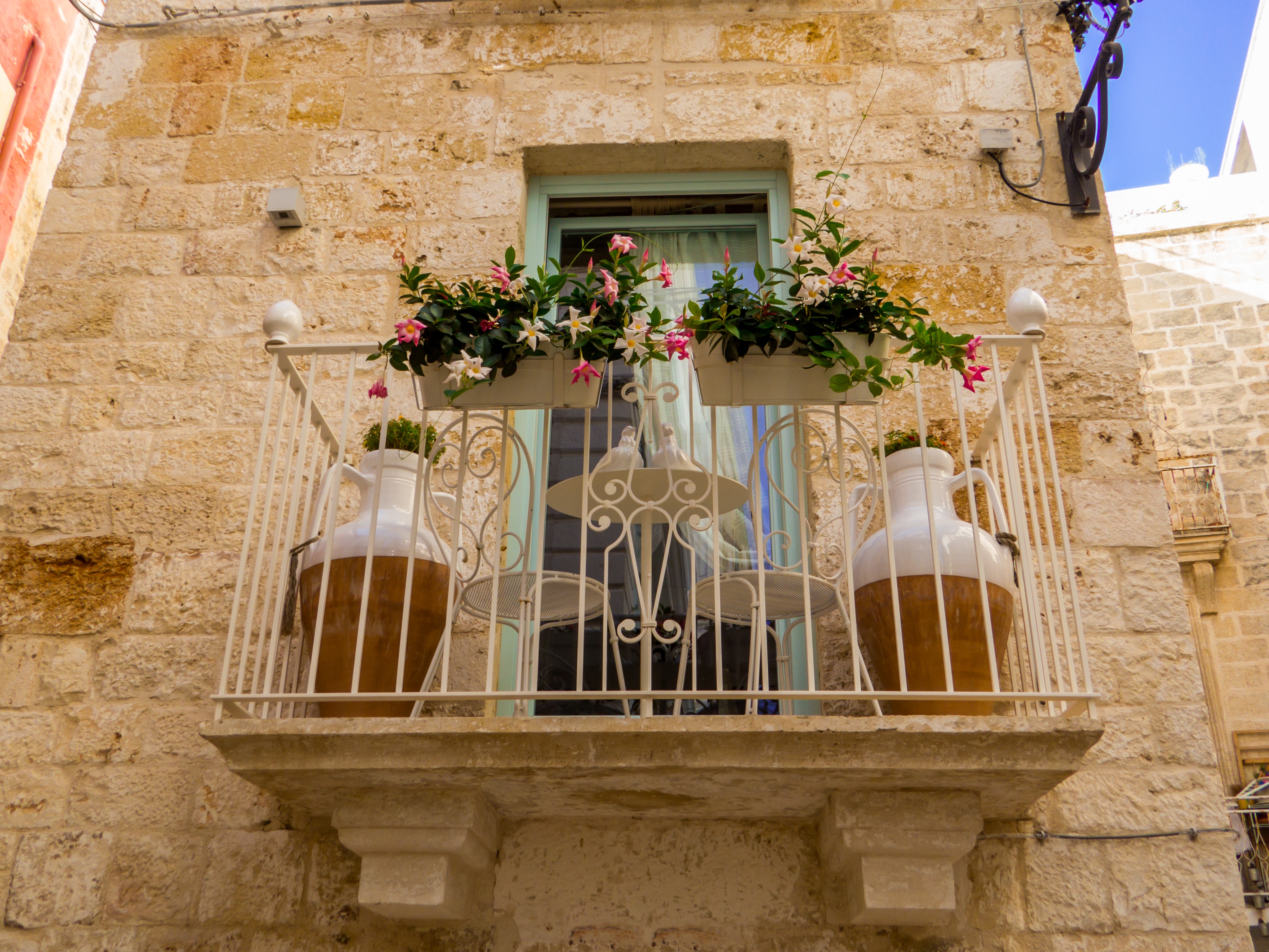 Traditionelt italiensk hus med romantisk blomsterbalkong i Puglia