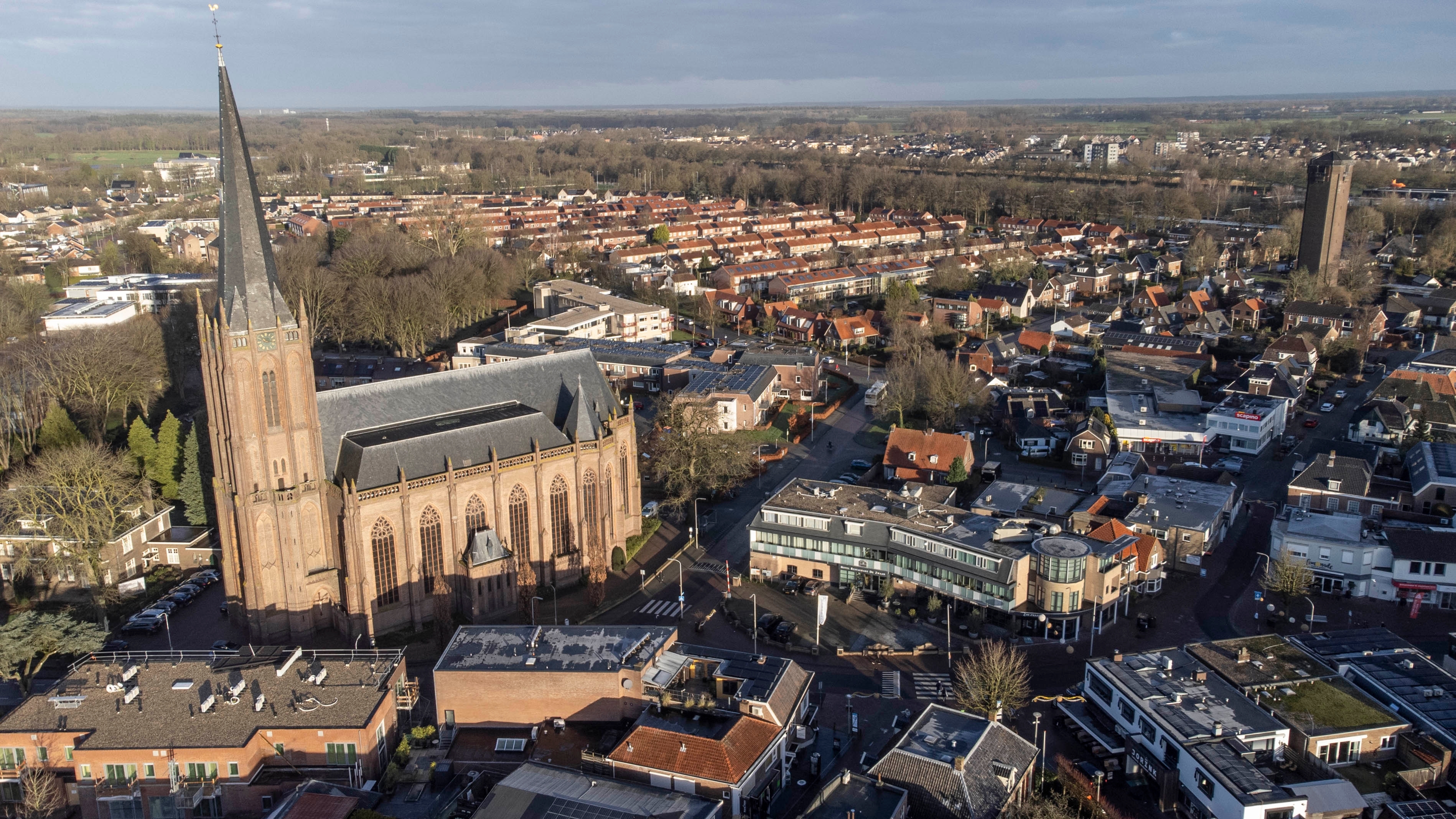 Luftfoto taget med drone over Raalte i Overijssel, Holland, med den gotiske basilika og byens centrum omgivet af grønne træer